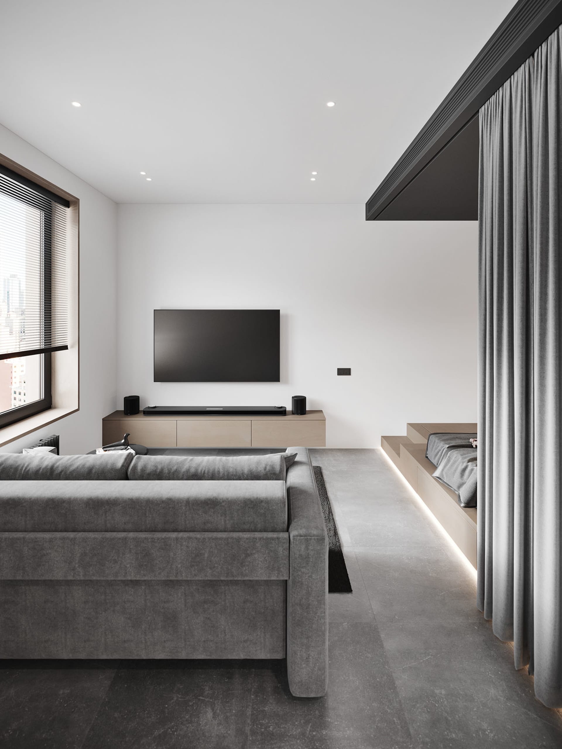 Modern minimalist living room featuring a concrete floor, grey sofa, and a television mounted on the wall.