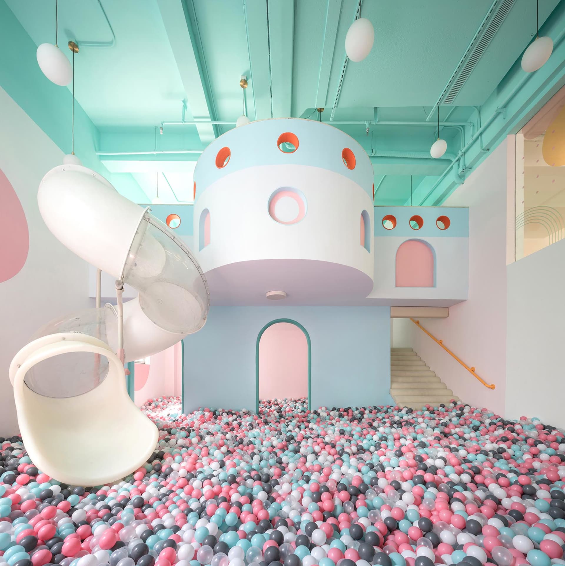 A playroom with a ball pit and a slide