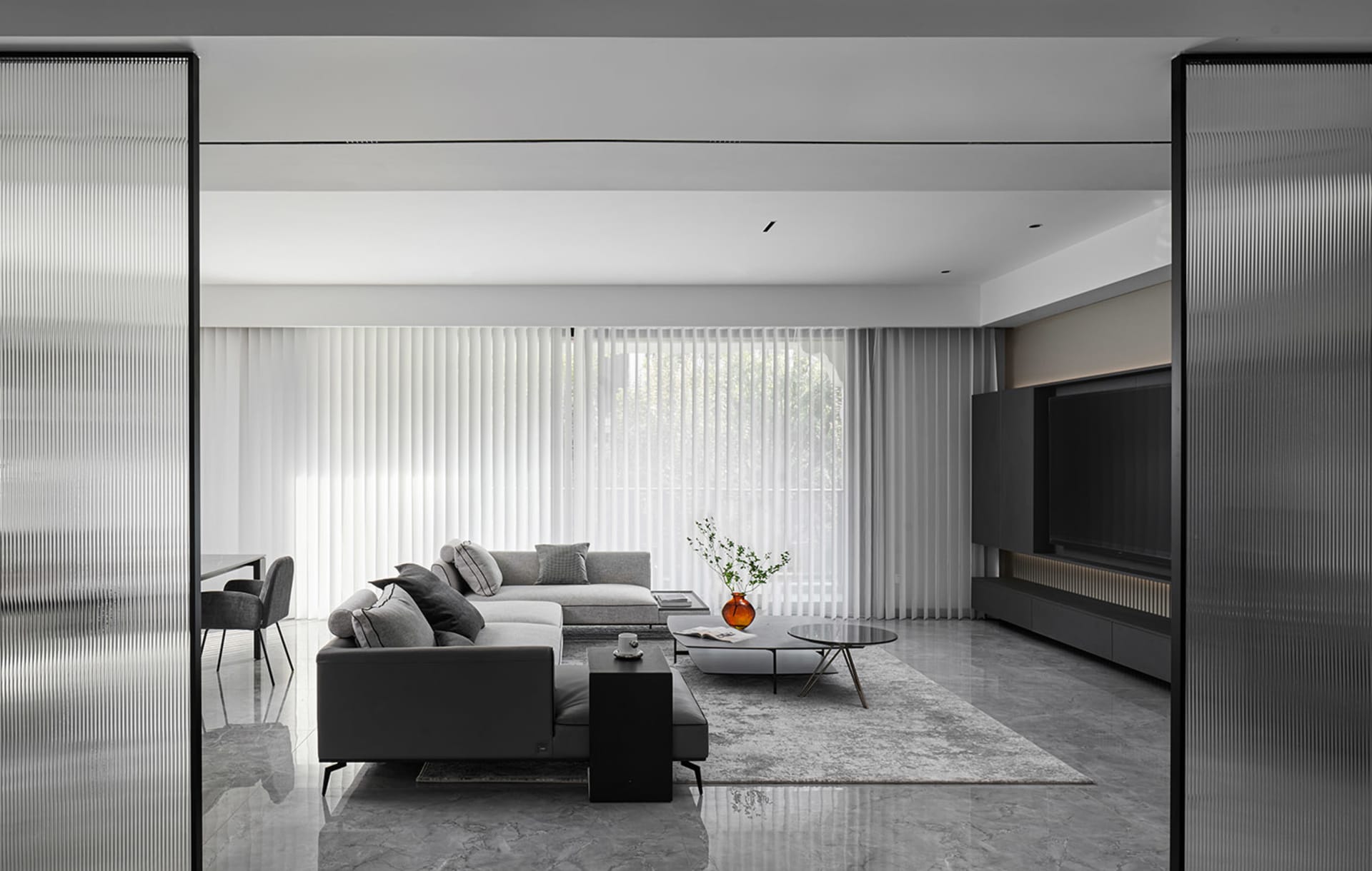 Modern minimalist living room featuring grey concrete furniture, large glass window, and sleek design.