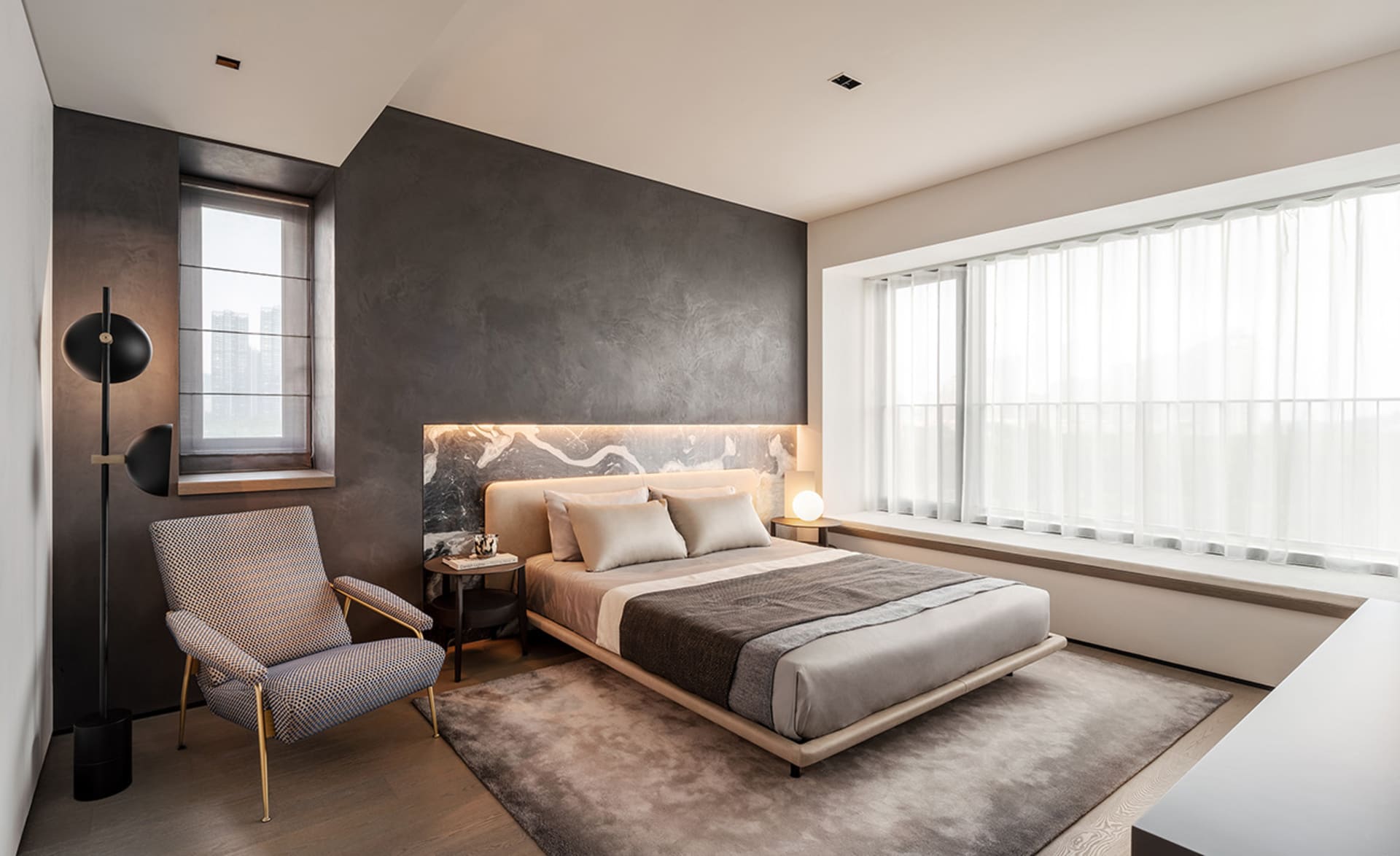 A modern bedroom featuring metallic bed frame, fabric bedding, and wooden floor.