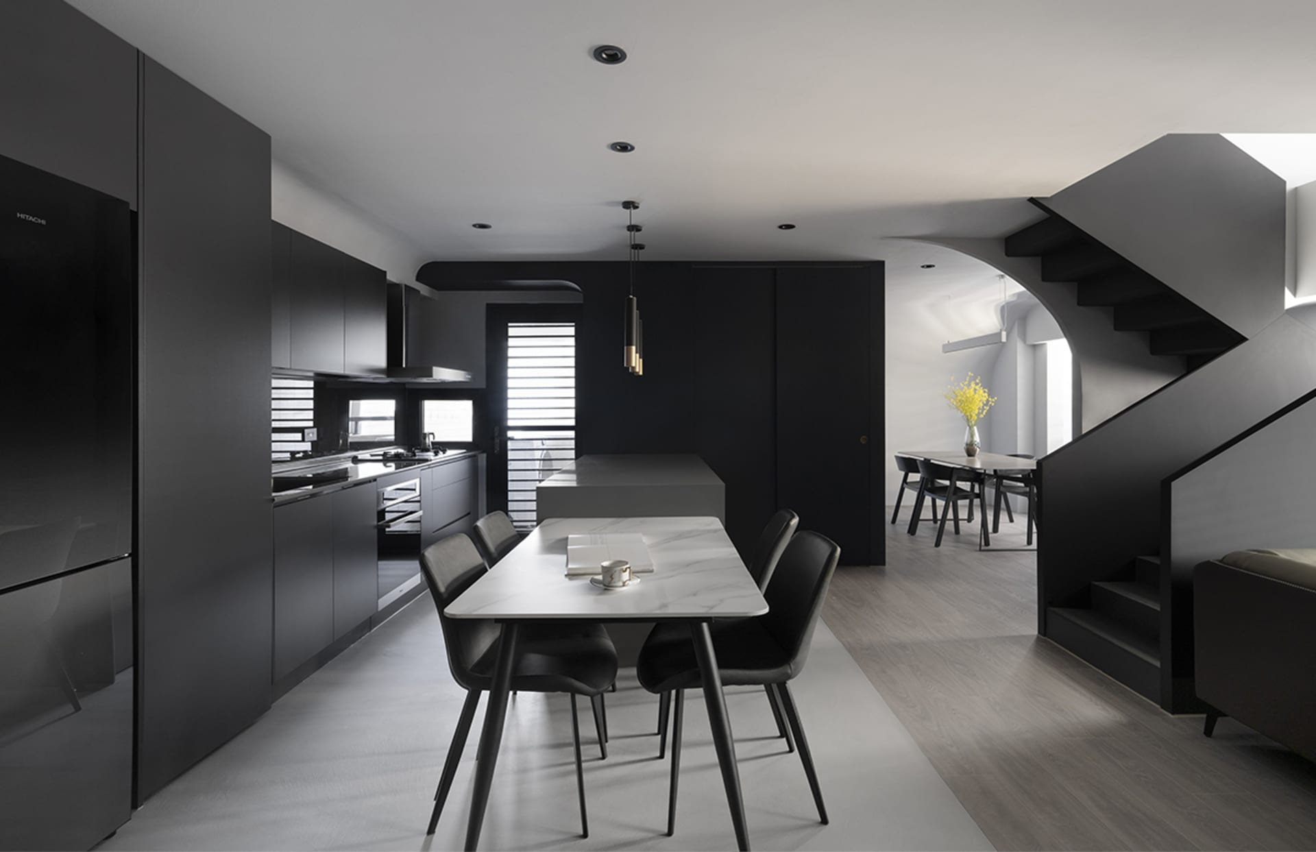 A modern black kitchen with metallic finishes.