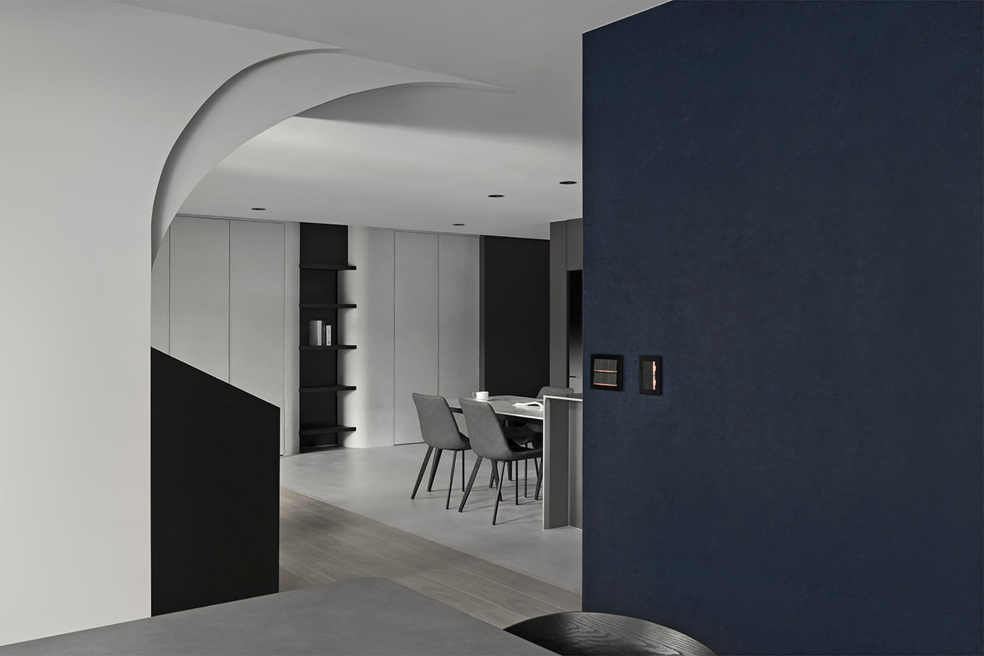 Modern minimalist dining room with concrete finishes featuring a sleek table and chairs.