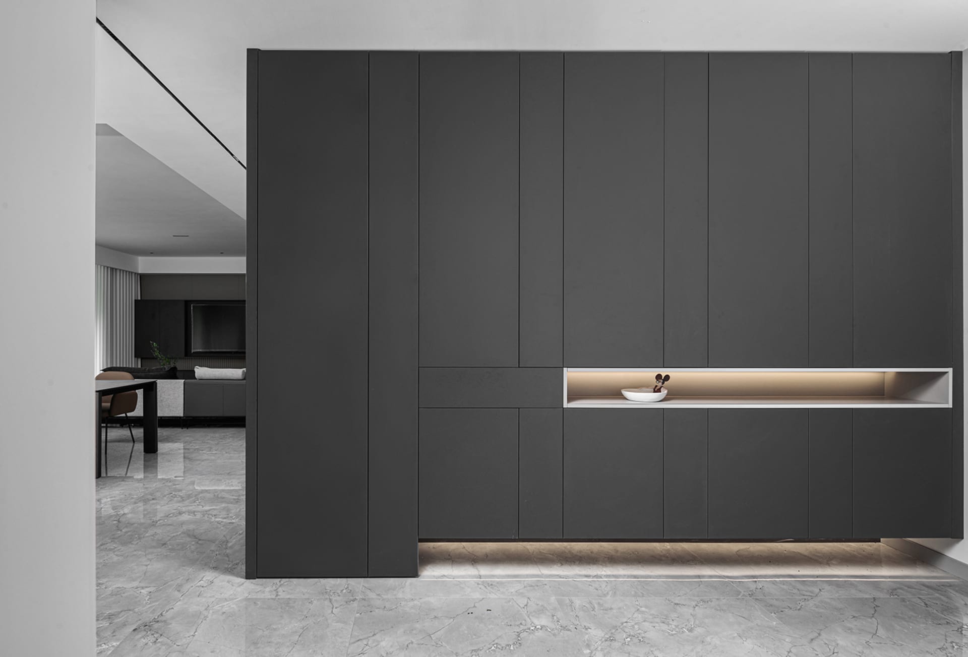 Modern minimalist home with black metallic paneling and marble flooring.