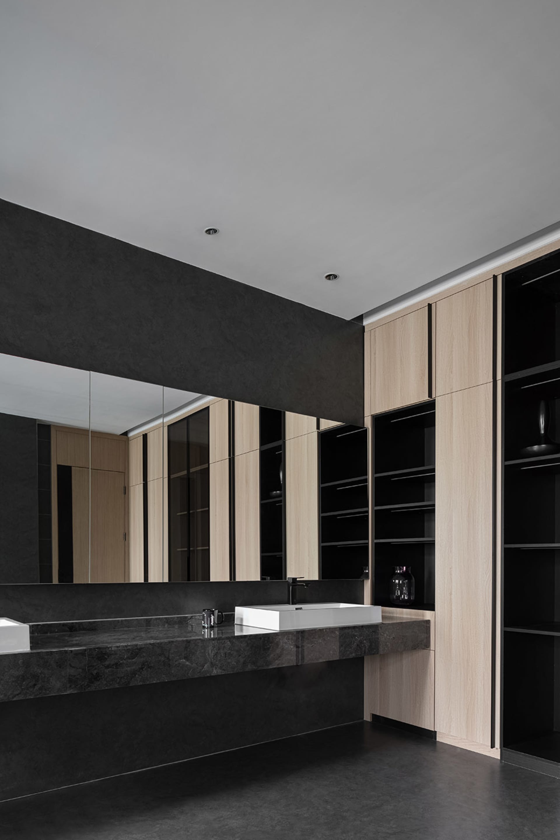 Modern minimalist bathroom featuring a concrete countertop and wooden cabinets.