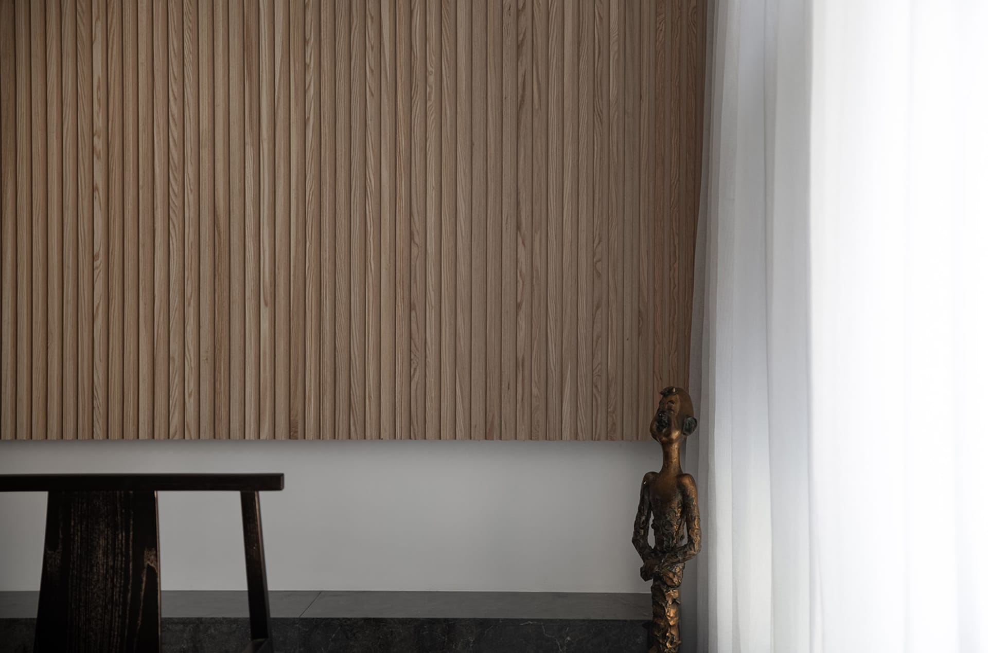 A minimalist bedroom featuring wooden paneling.