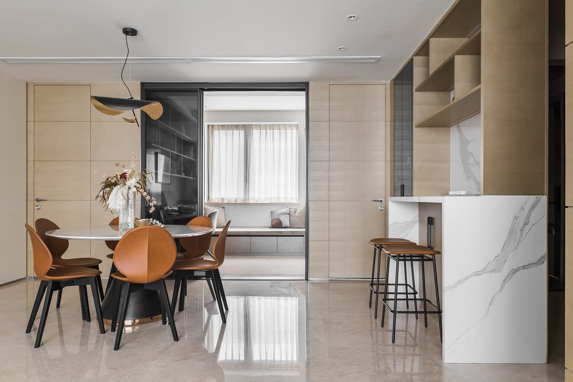 A modern kitchen interior with a marble countertop and wooden flooring.