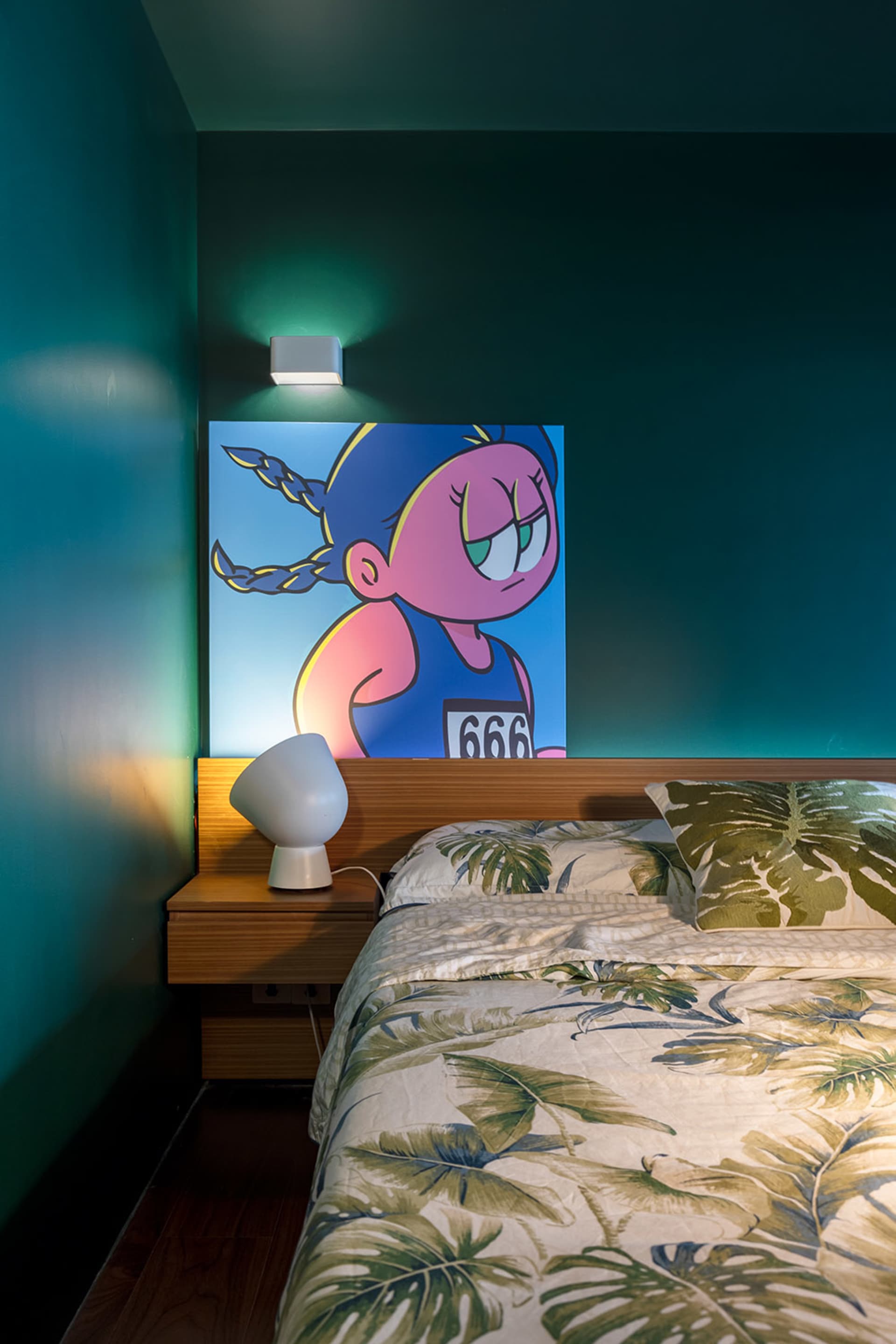 A modern bedroom with a wooden bed and a green wall with a cartoon character poster.