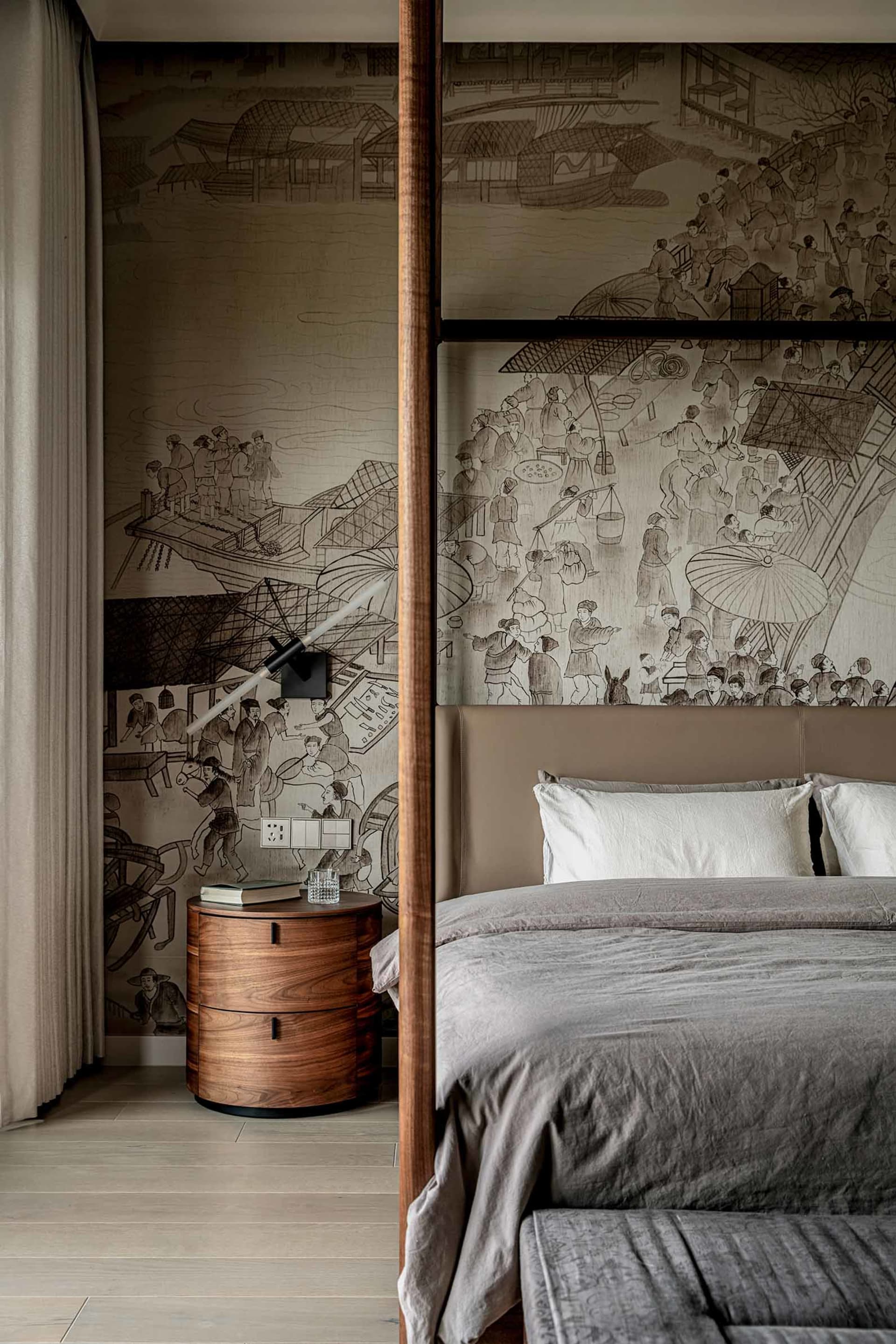 A modern bedroom featuring a four-poster bed with a brown headboard, gray bedding, and a wooden bedside table with a lamp and