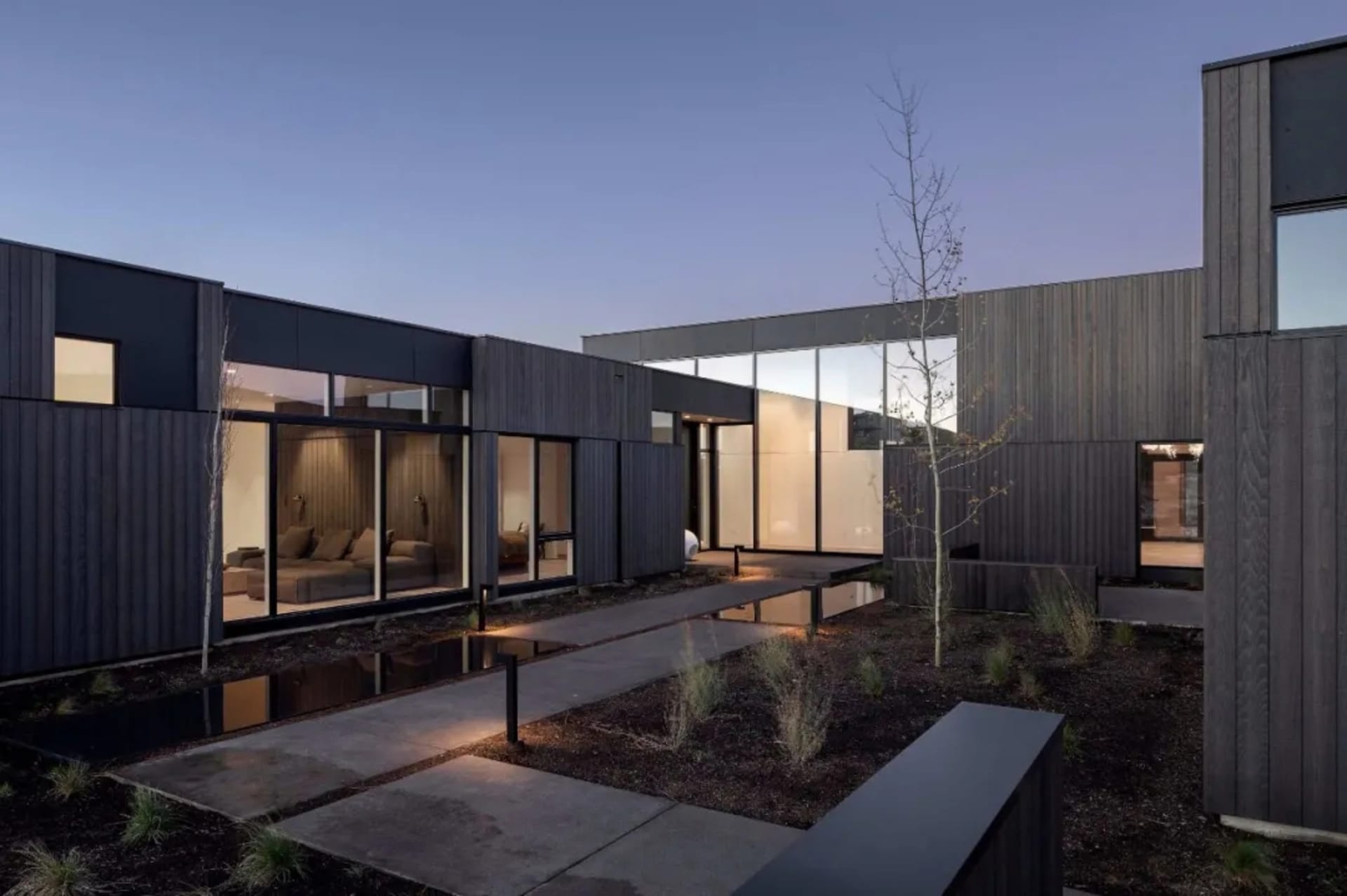 A modern house exterior featuring dark wood and glass materials.