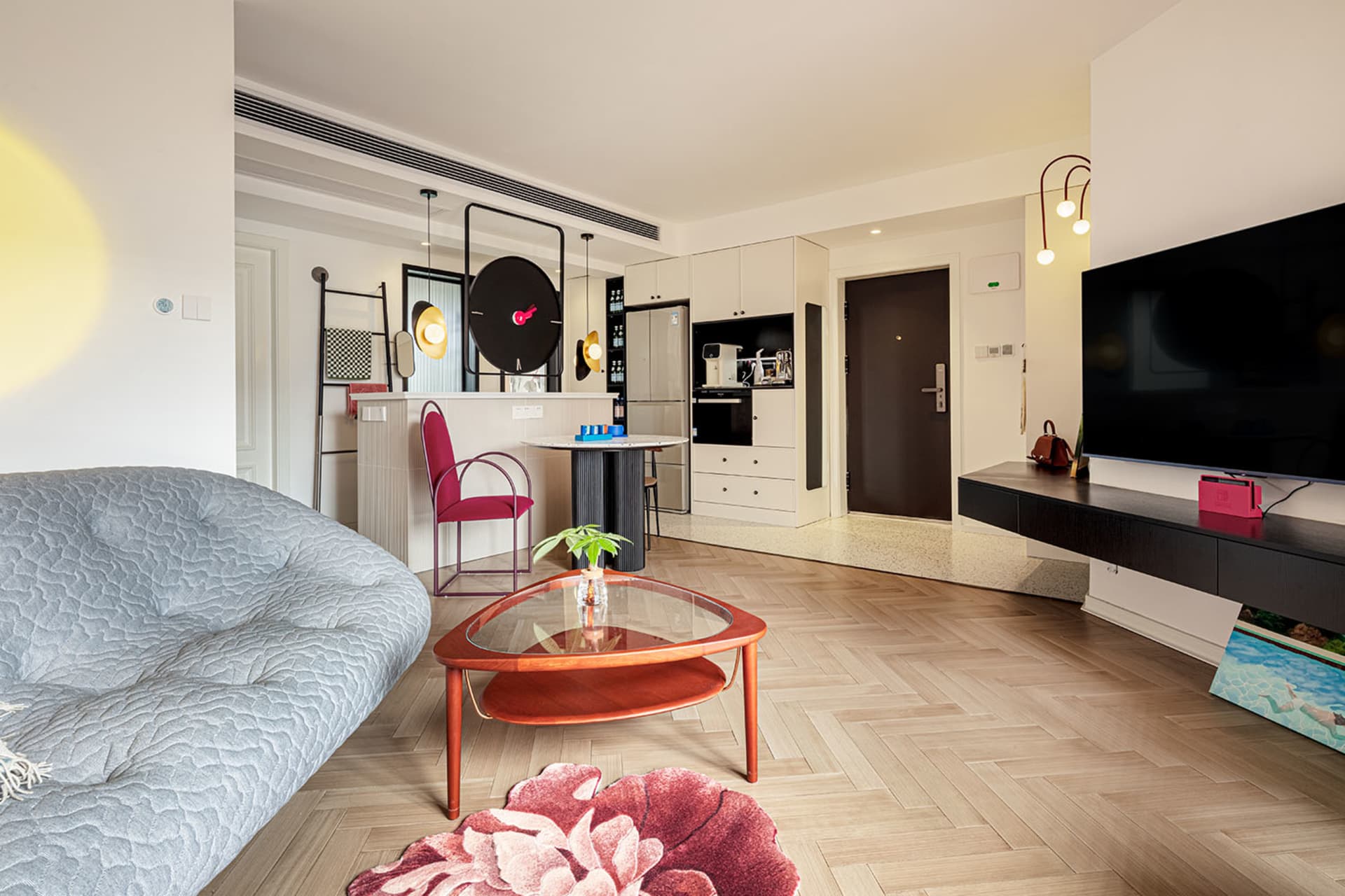 A modern living room with wood flooring and glass coffee table.