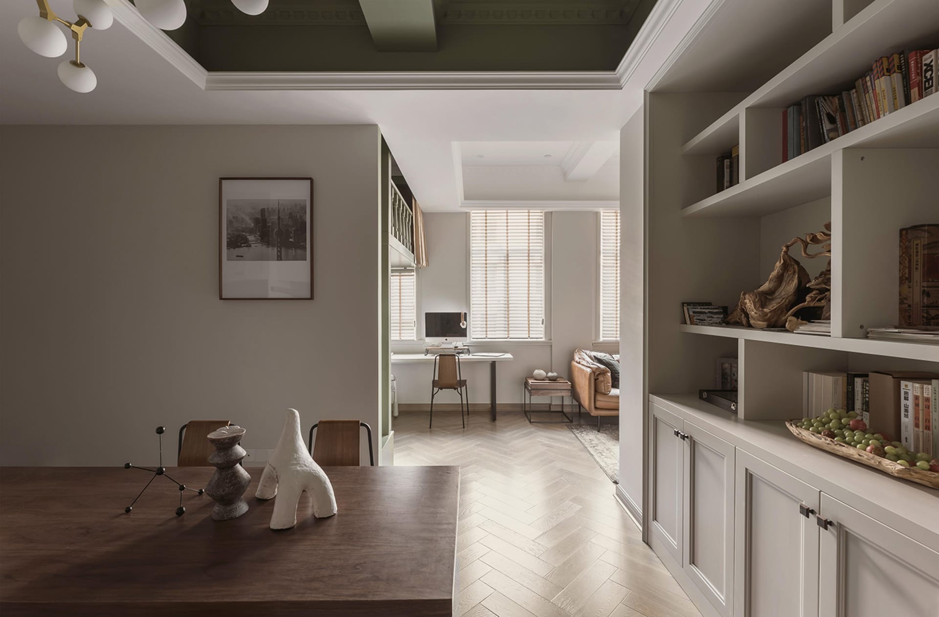 A modern living room with wooden furniture, white walls, and a bookshelf filled with books and decorative items.