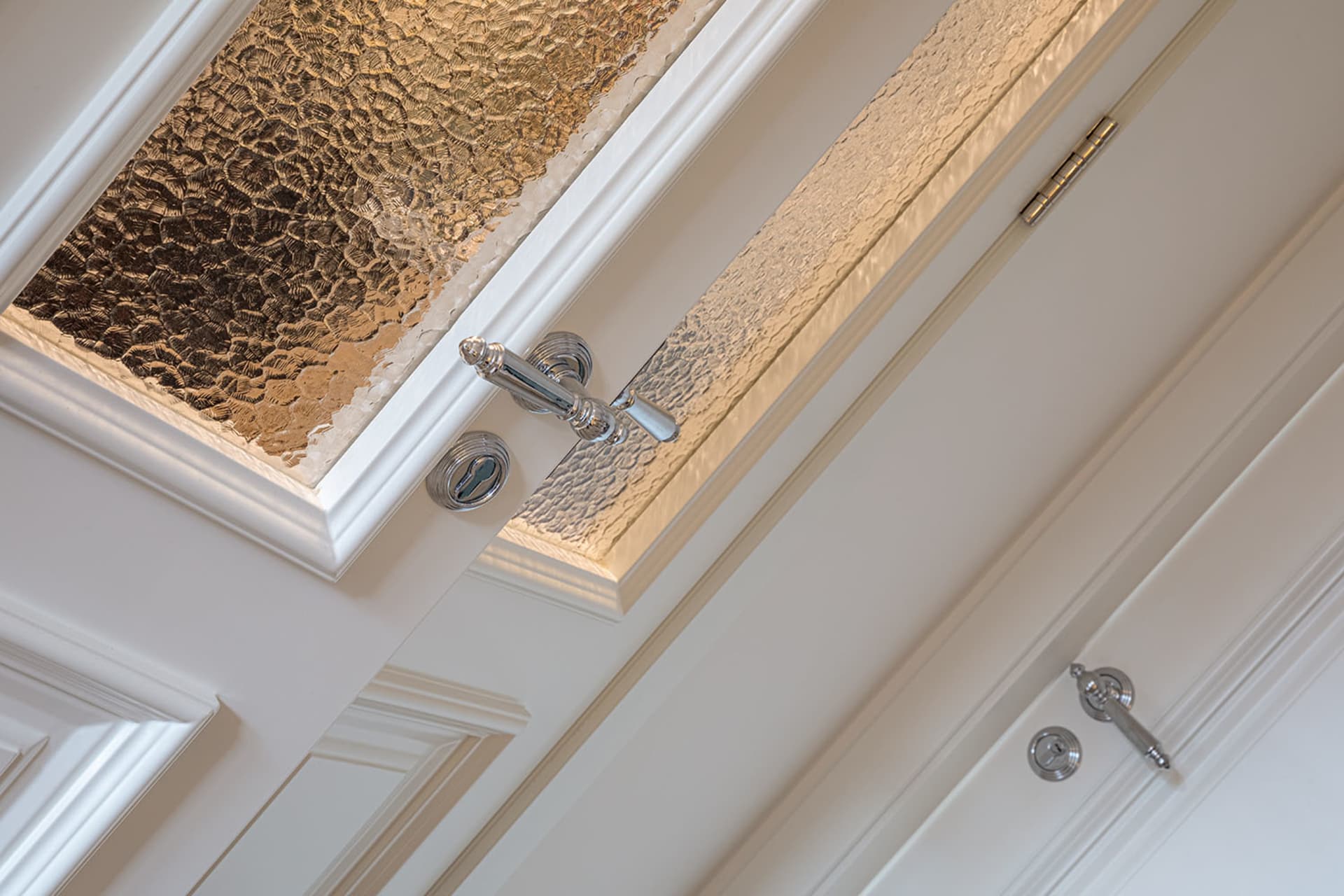 Close-up view of elegant glass cabinet doors featuring textured glass inserts.
