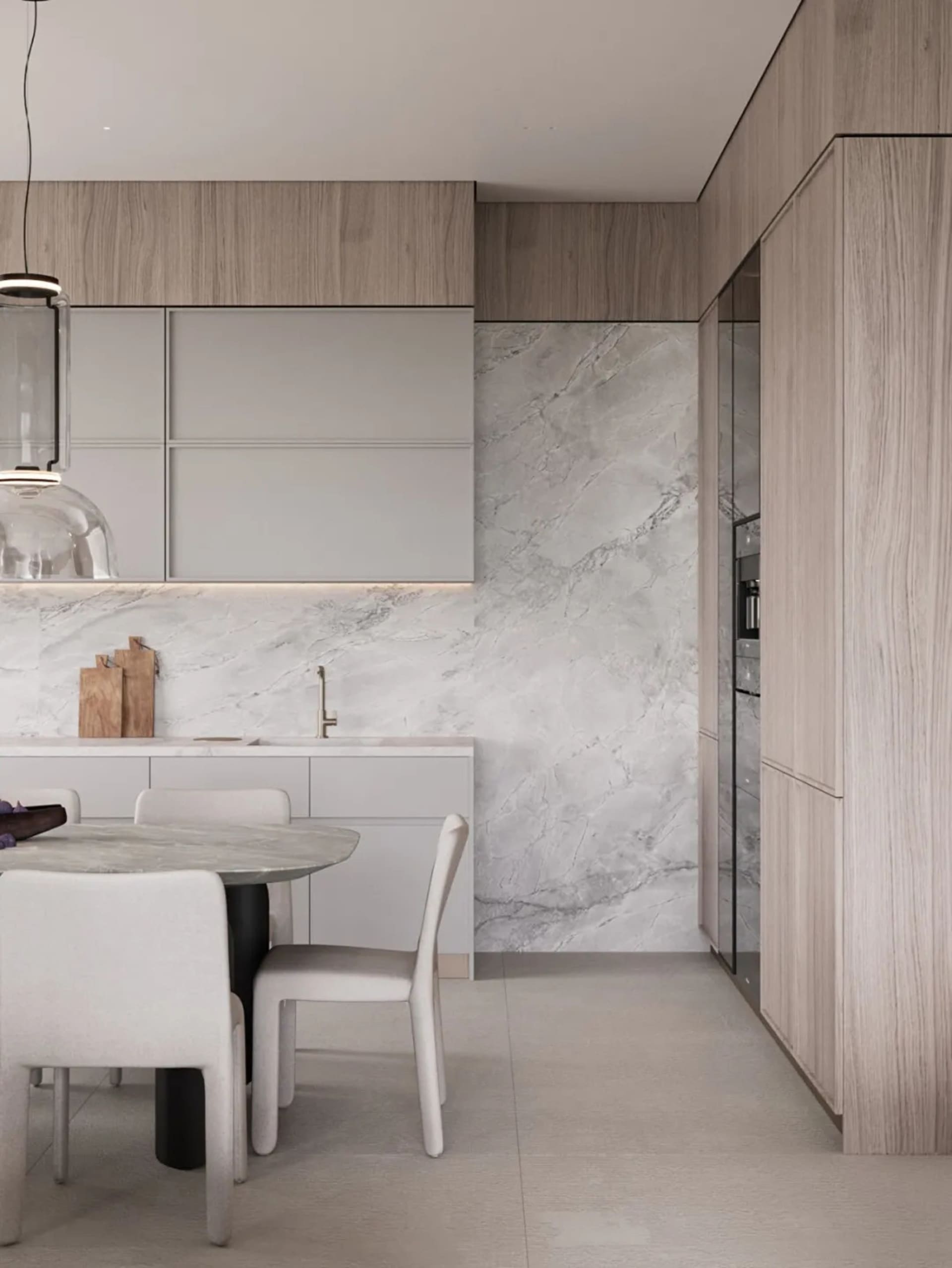 Modern minimalist kitchen featuring marble finishes, white cabinets, and a round dining table with chairs.