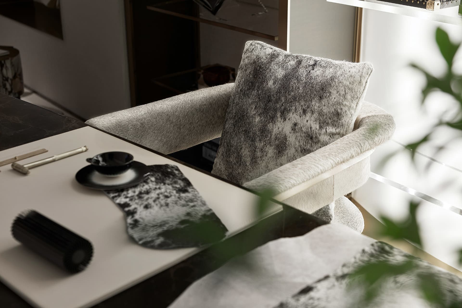 Minimalist living room featuring a cowhide accent pillow and chair.