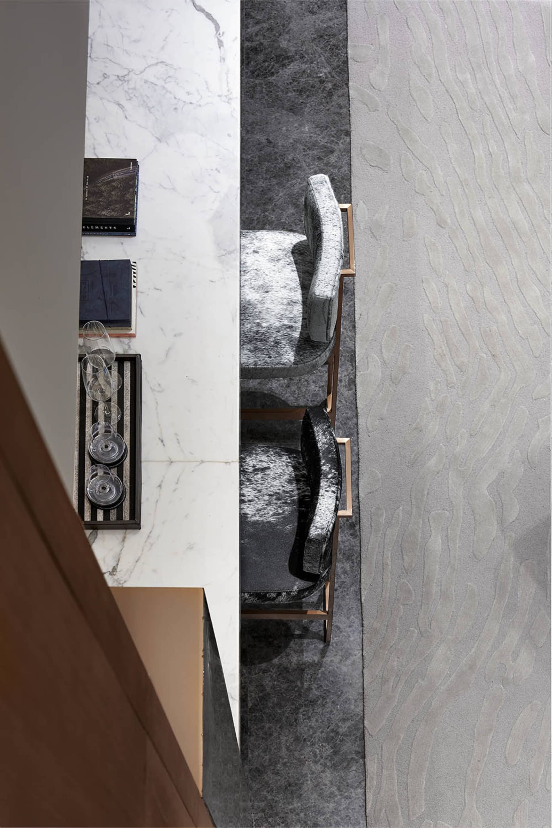 A modern dining room features marble countertops and fabric upholstered chairs with metallic frames.