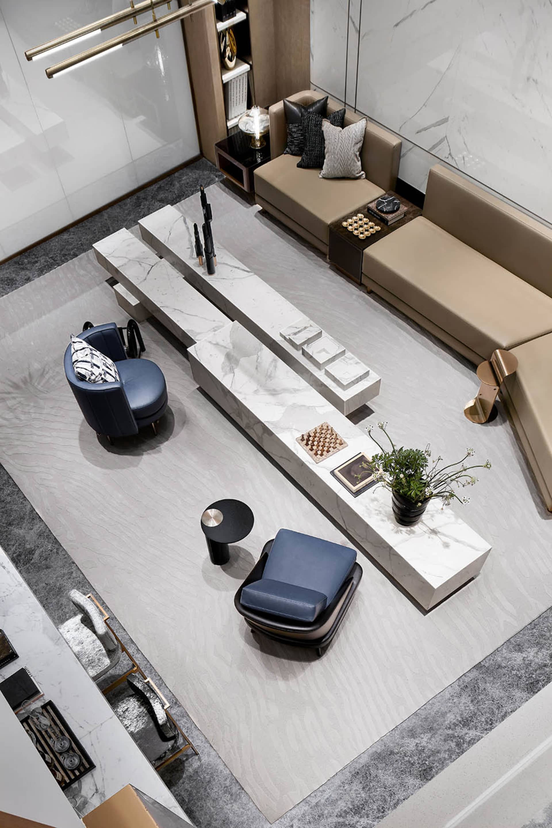 A modern living room featuring a sleek marble centerpiece with a dark armchair and a beige sofa.