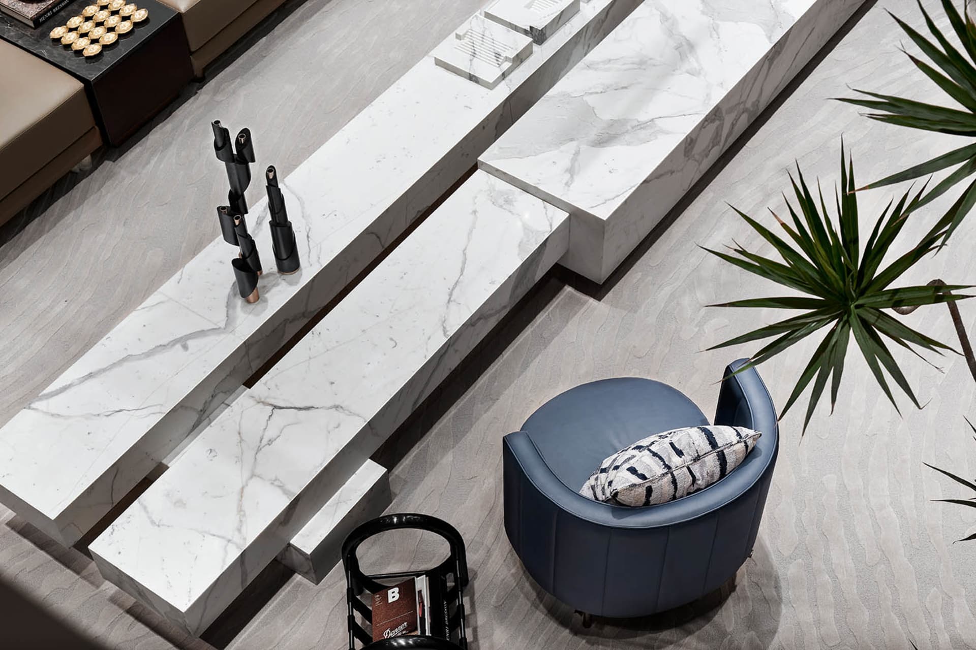 A modern living room featuring marble elements and a blue armchair.