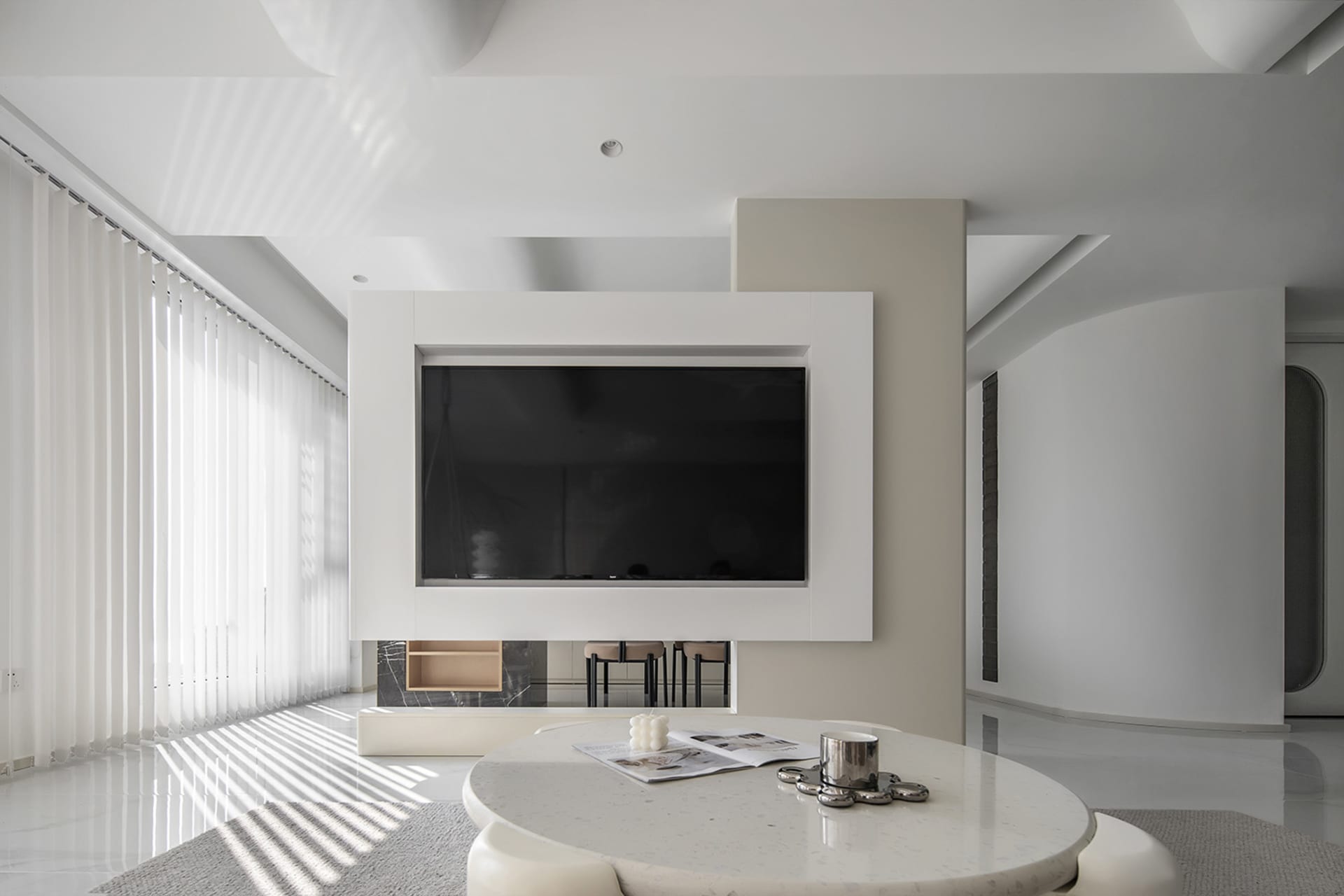 A minimalist living room with a white and black color scheme and concrete elements.