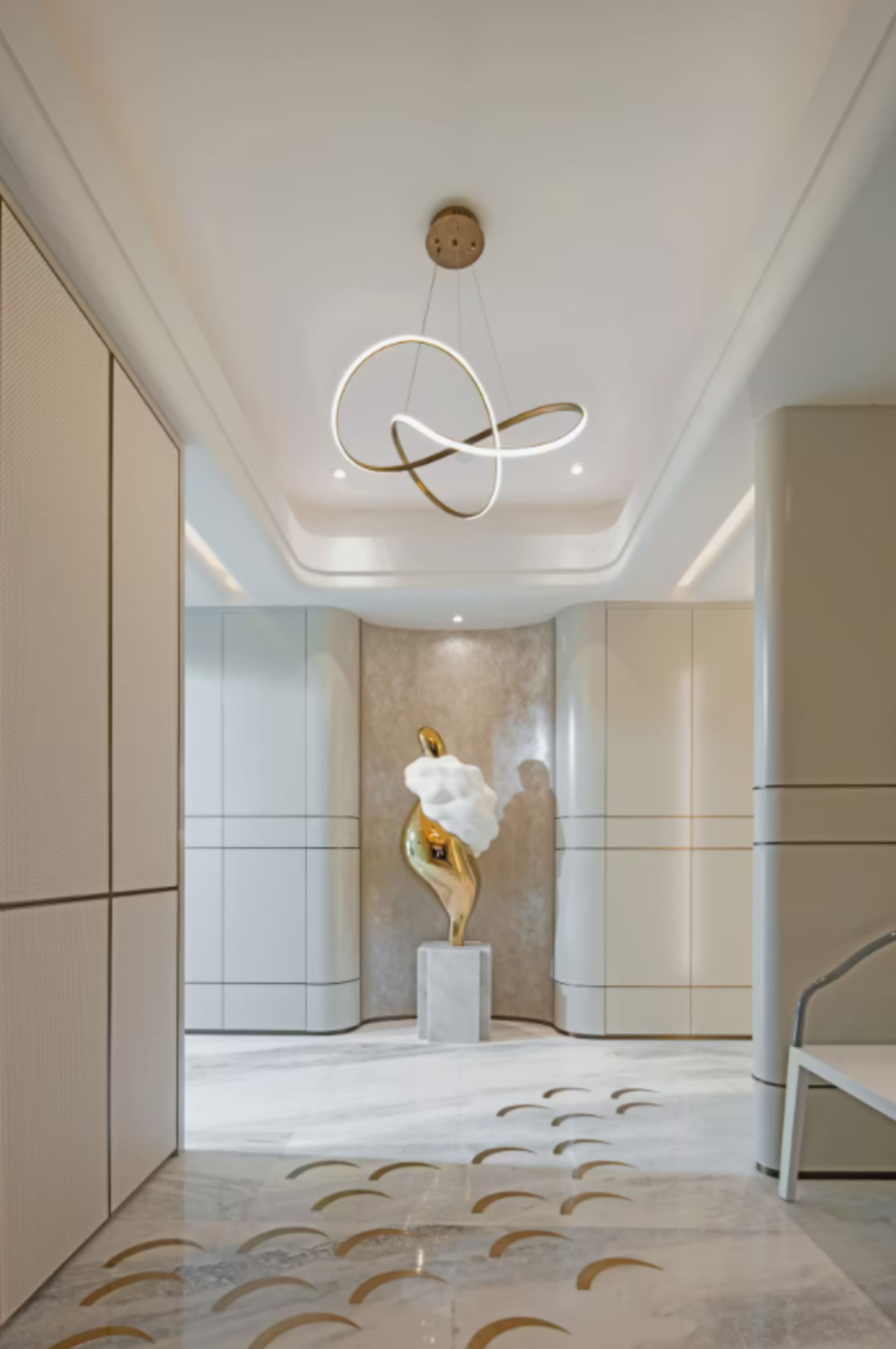 Modern interior design featuring a corridor with marble floor and a gold abstract sculpture.