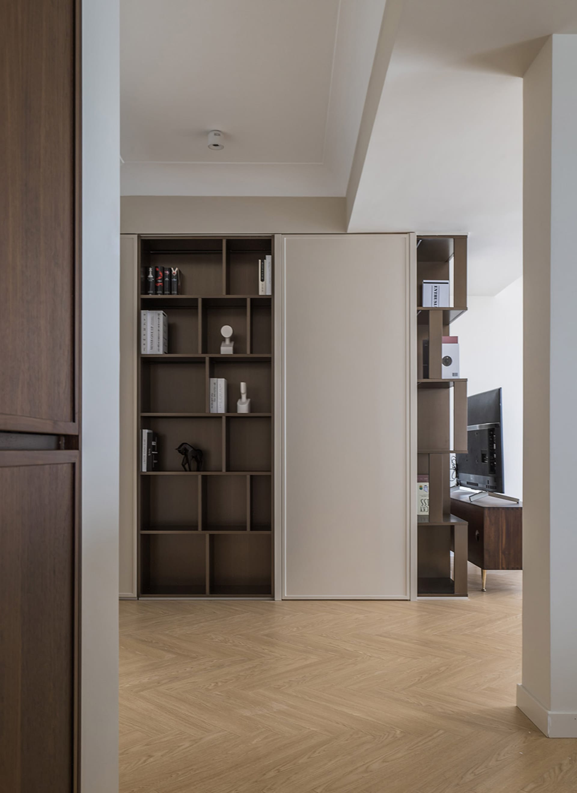 Modern living room with built-in storage shelves and a combination of wood and metal materials