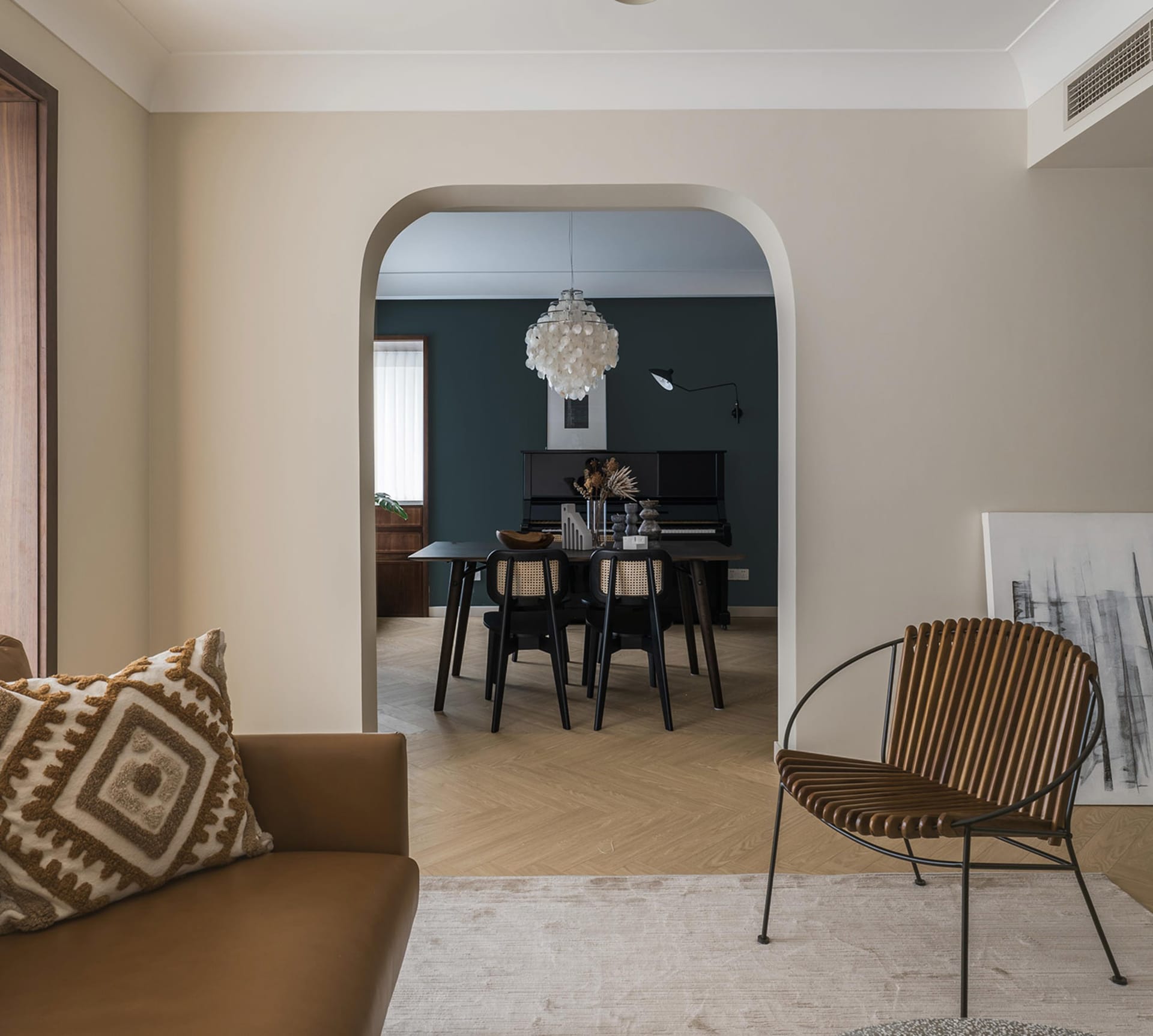Modern living room featuring leather and woven furniture with minimalist decor.