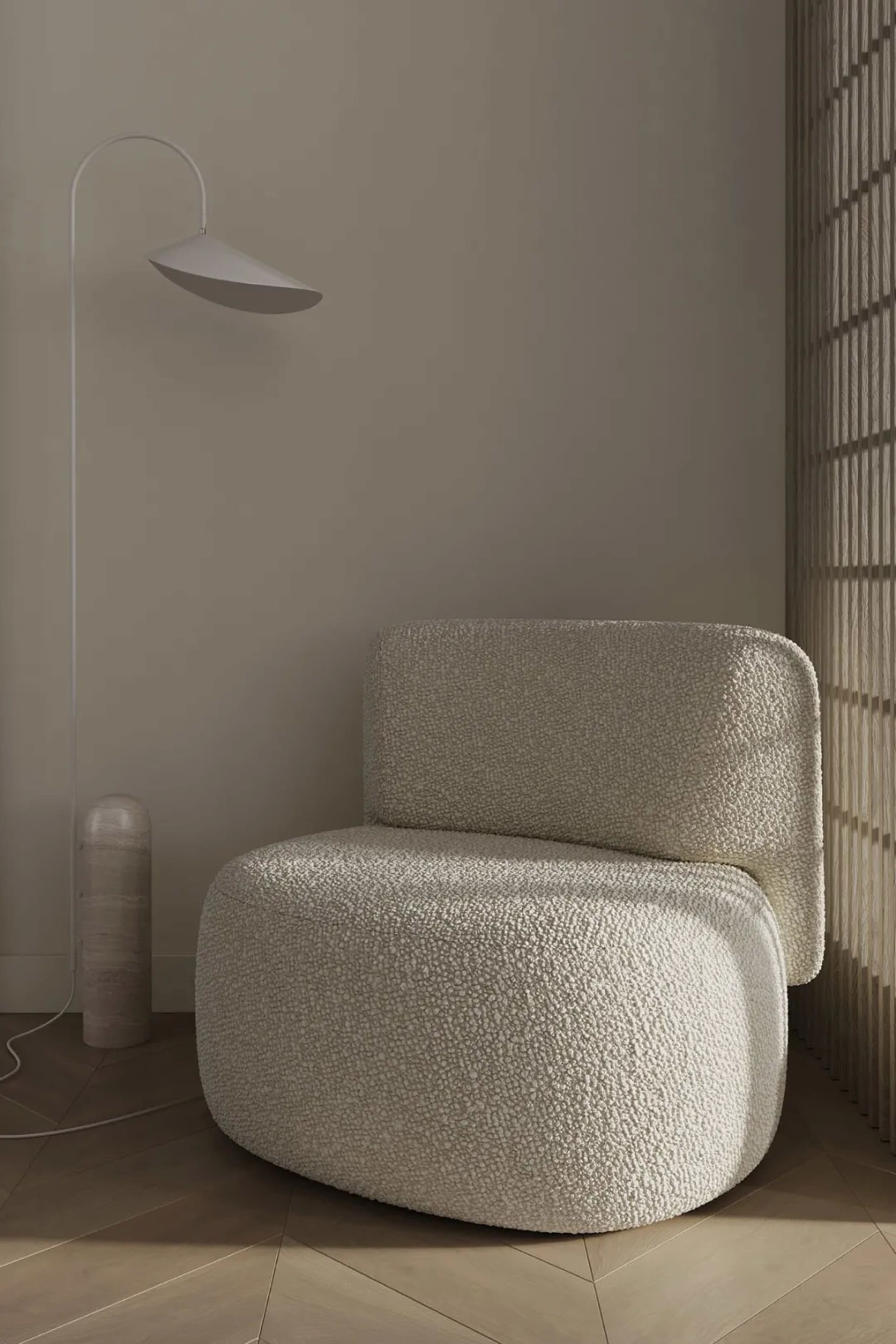A modern interior with a textured fabric chair and minimalist lamp.