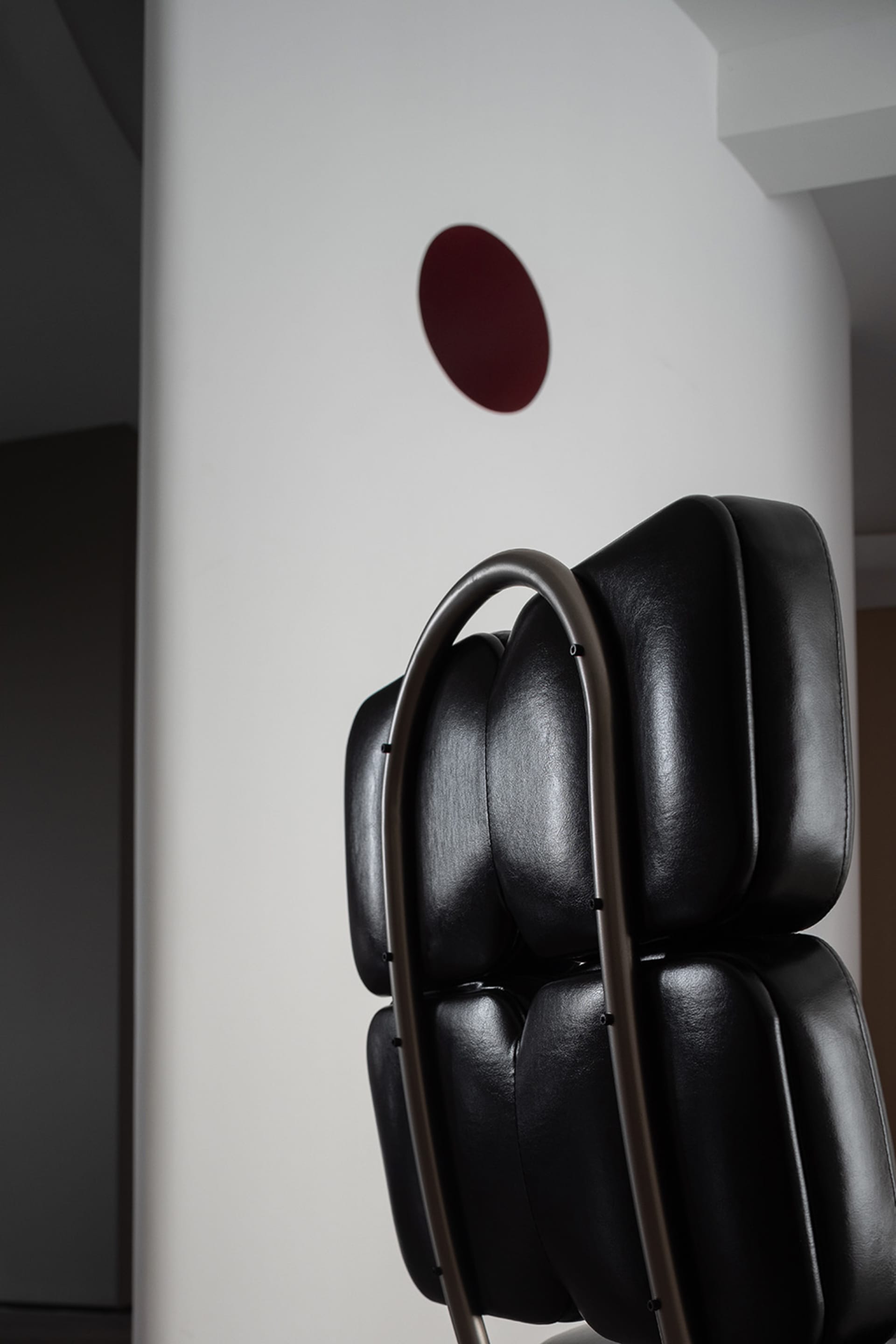A black leather industrial-style chair with a unique design.