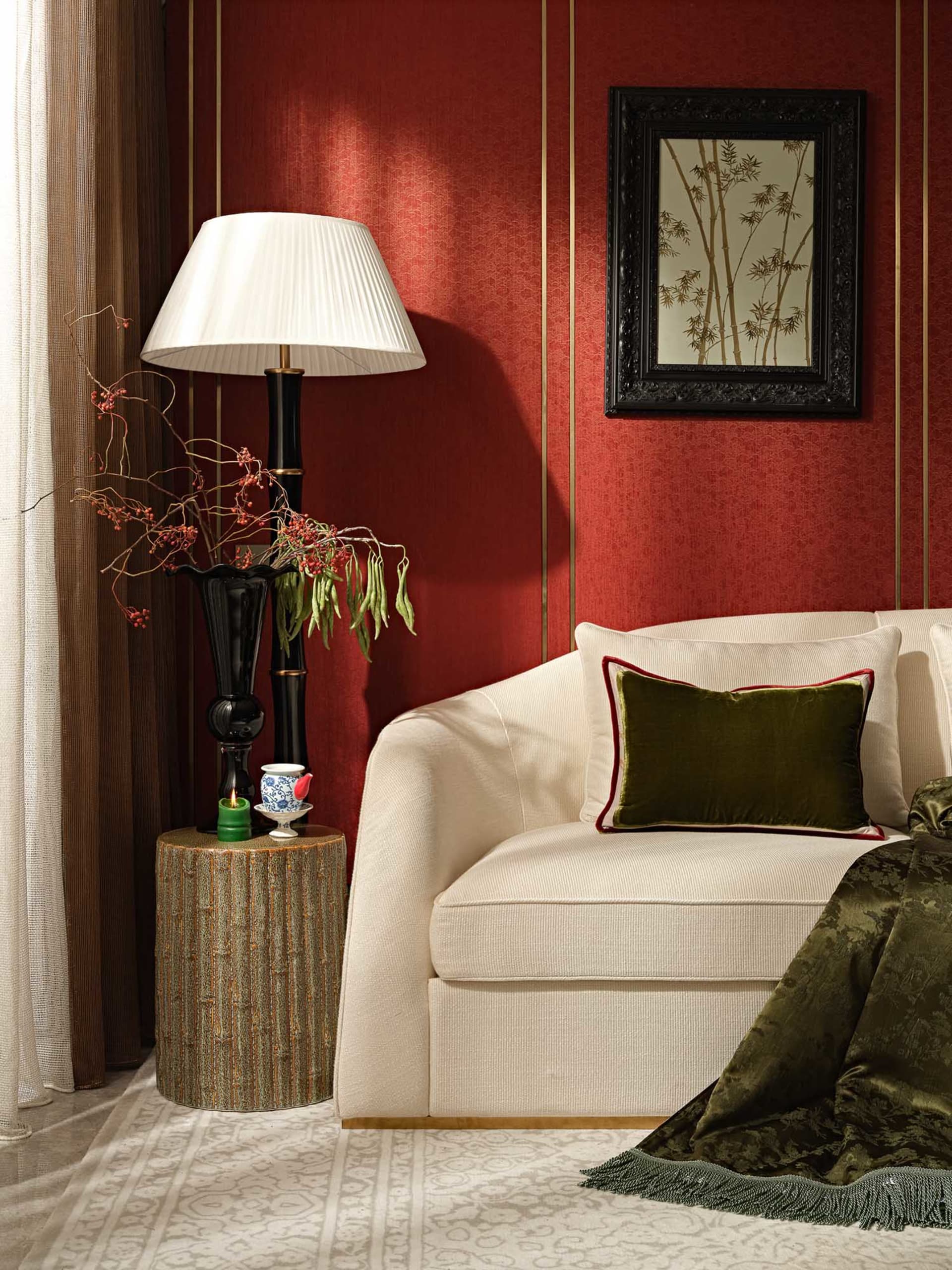 A modern living room with a white couch, red walls, and decorative plants.