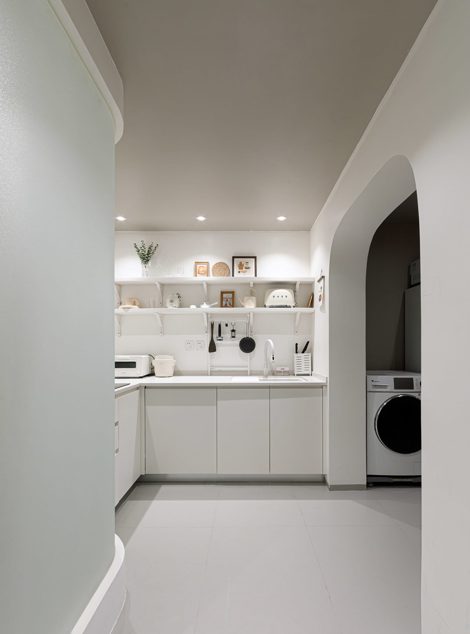 Minimalist kitchen with white cabinets and modern appliances.