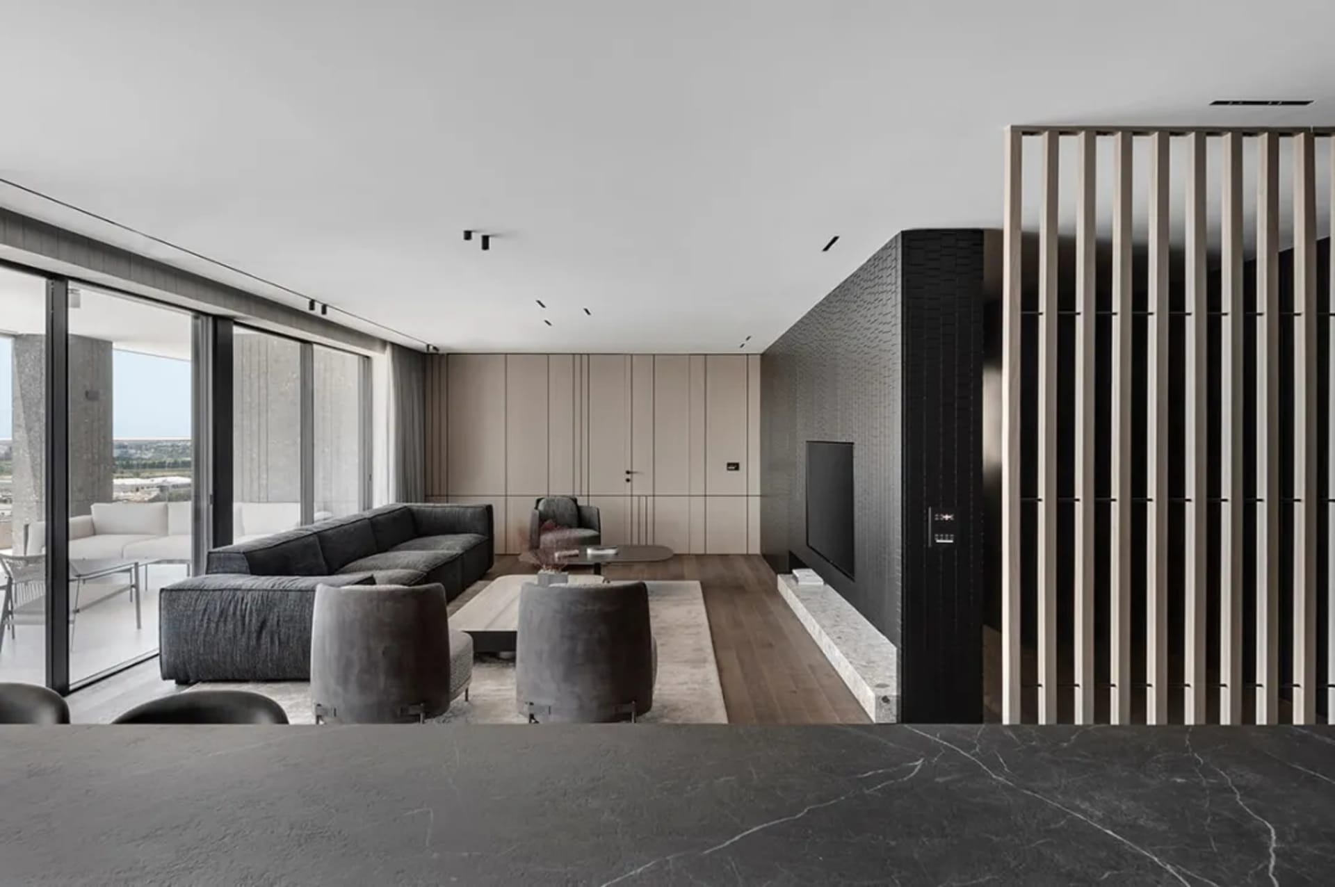 Modern living room featuring a sleek, minimalist design with concrete walls and flooring.