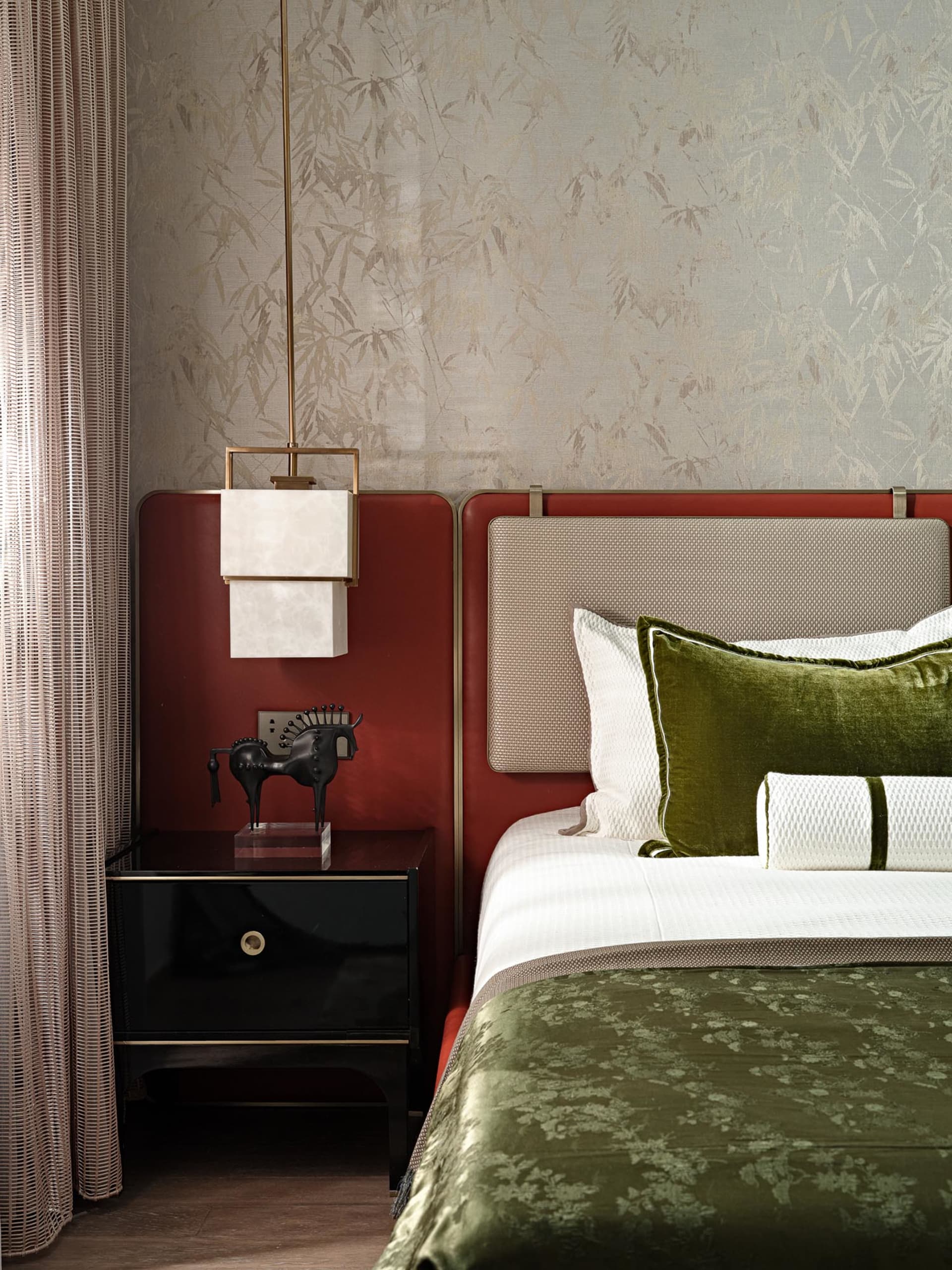 Modern minimalist bedroom with green velvet bedding, white walls, and red accents