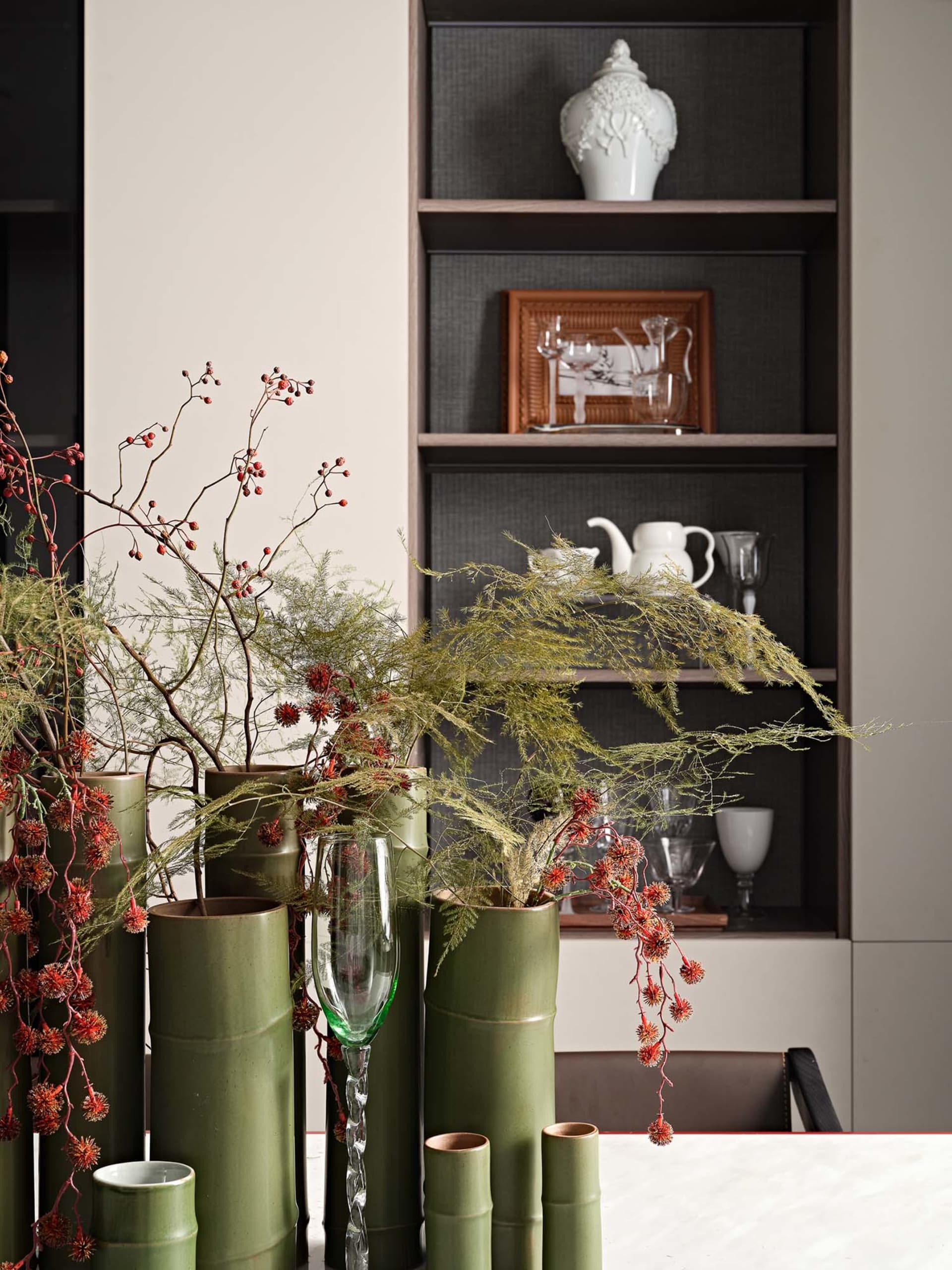 Still life arrangement featuring ceramic vases and greenery in an urban residential setting.