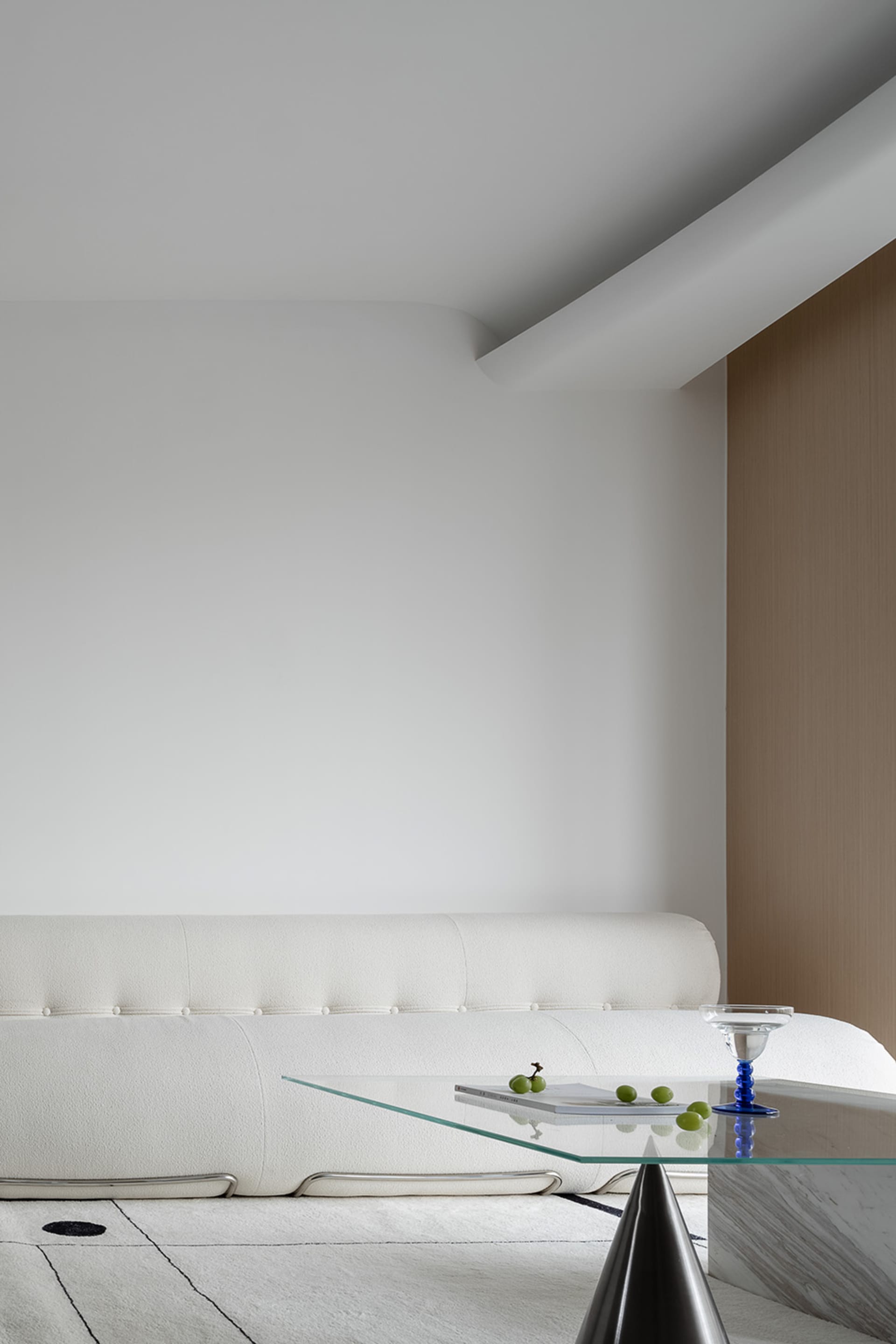 A modern living room featuring glass, marble, and concrete materials.