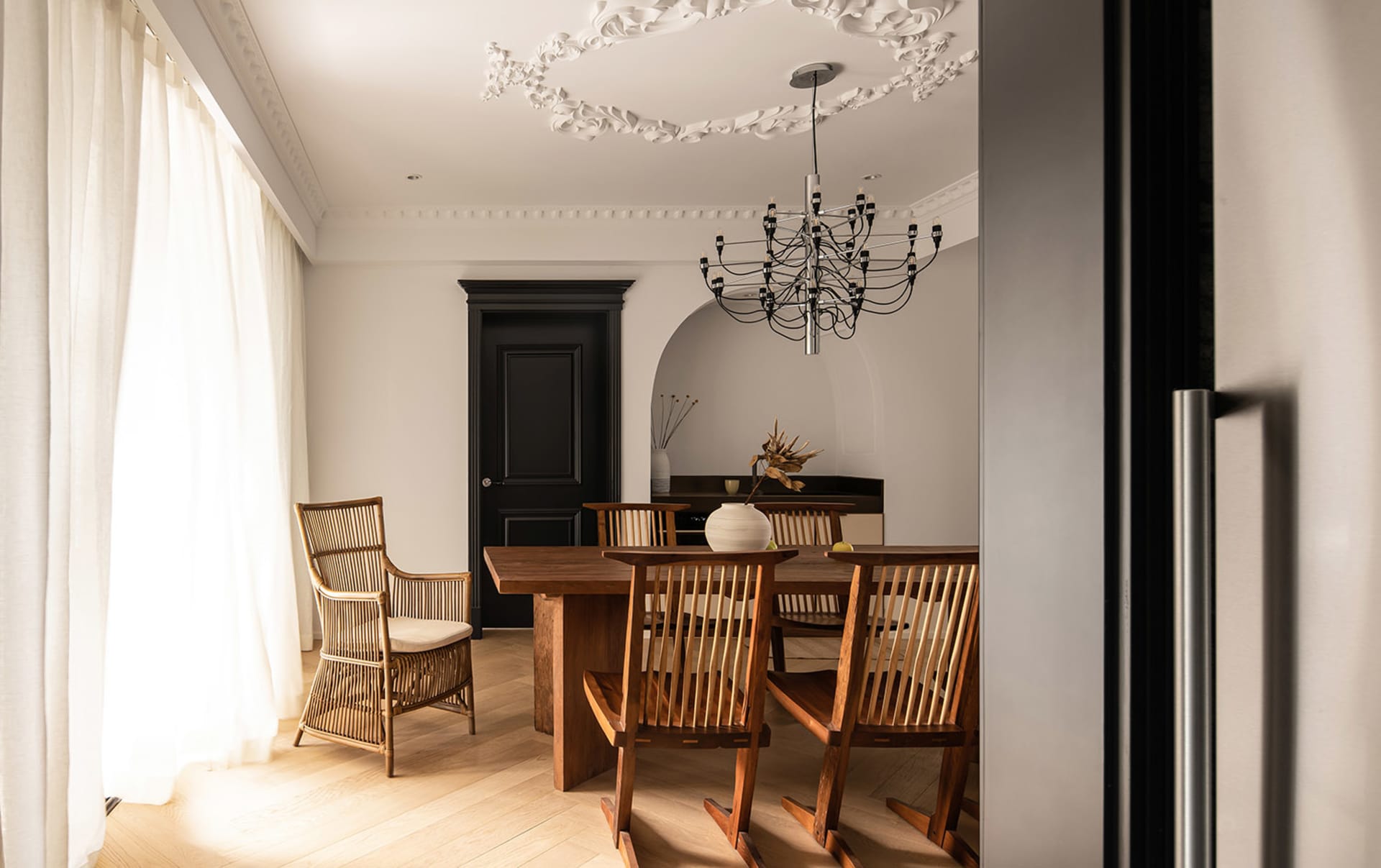 Modern minimalist dining room featuring wooden furniture and canvas accents