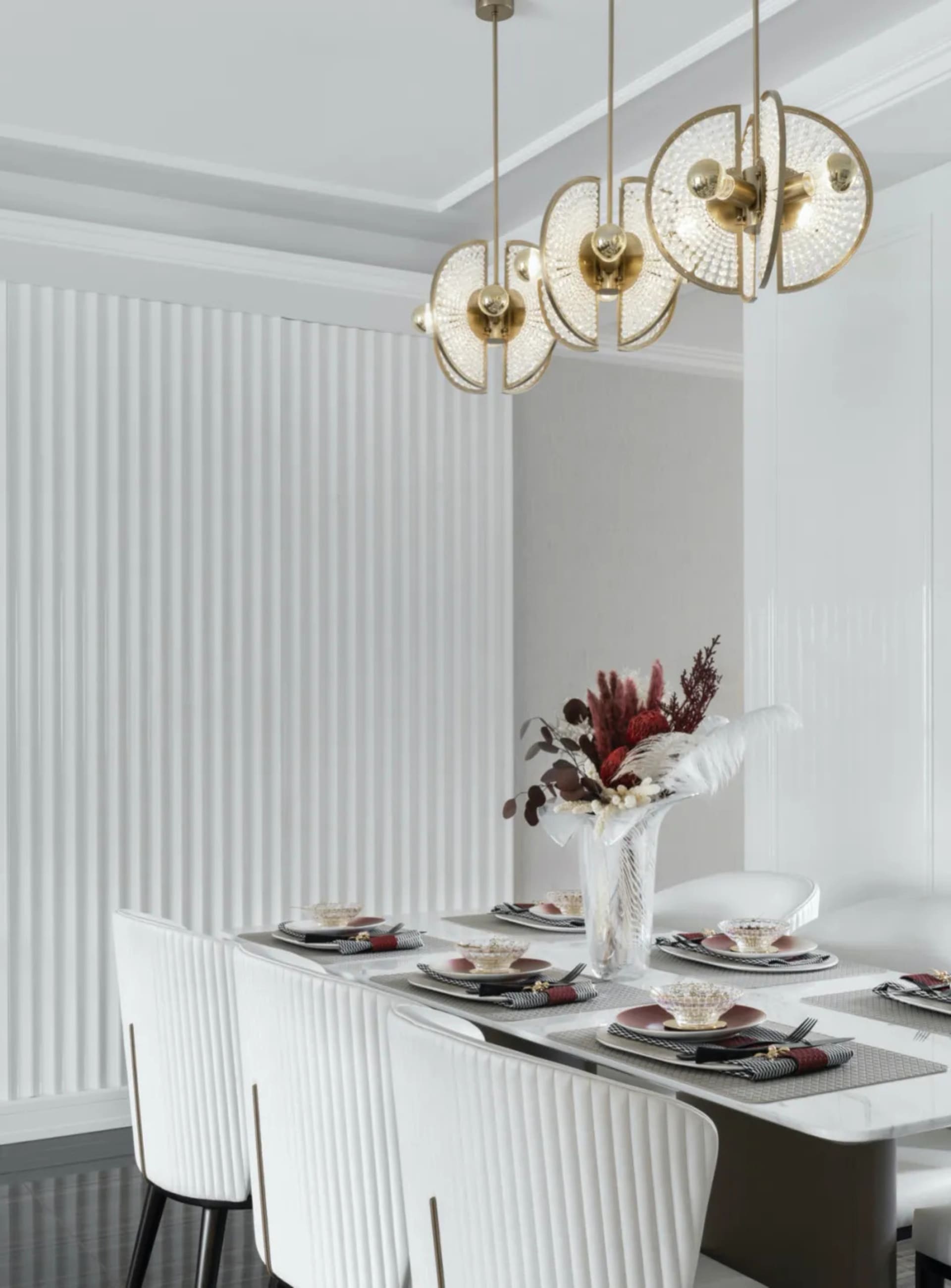 Modern dining room with white decor, including tables, chairs, and hanging lights.