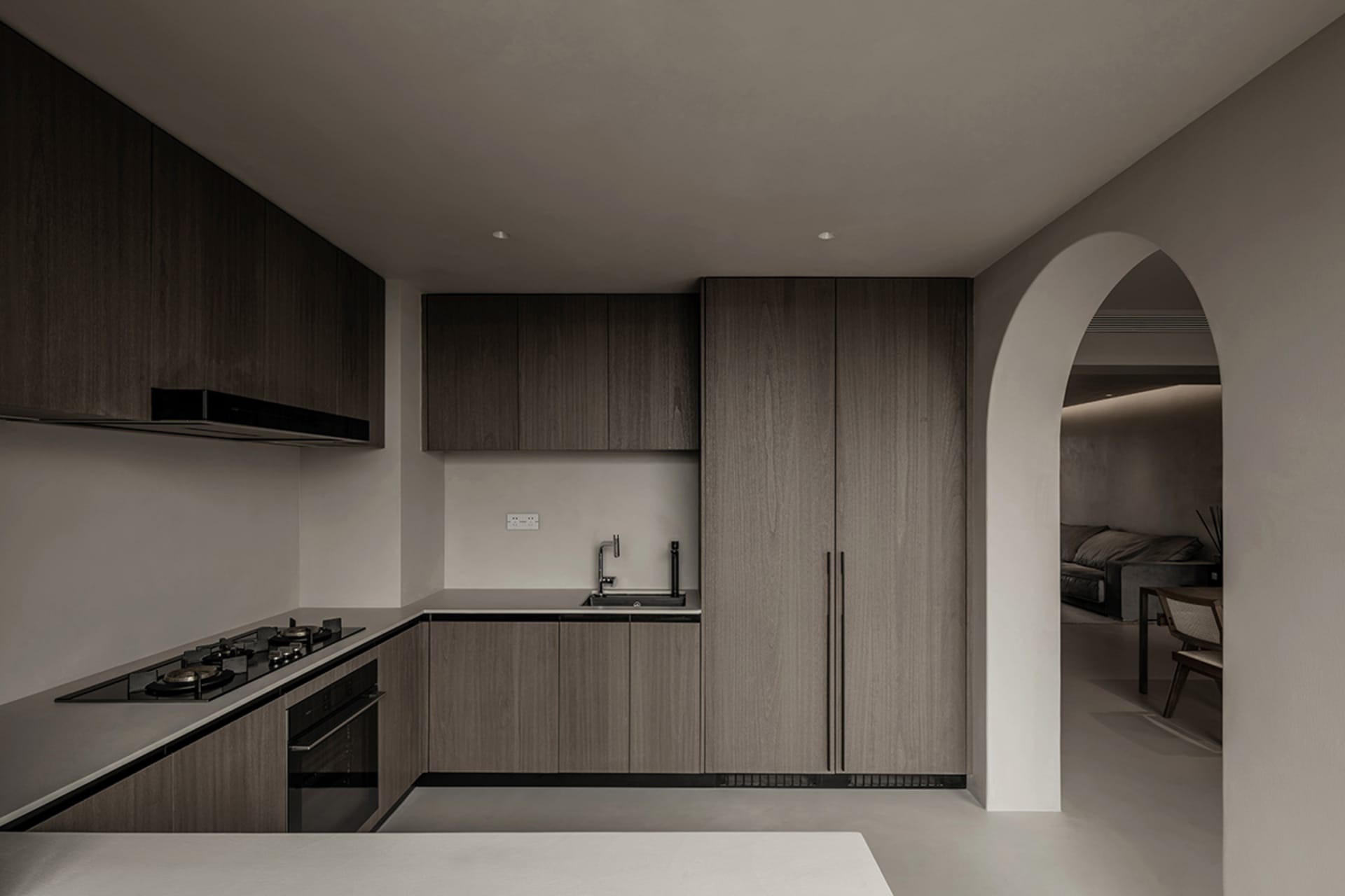 Modern minimalist kitchen with dark wood cabinets and a white countertop.
