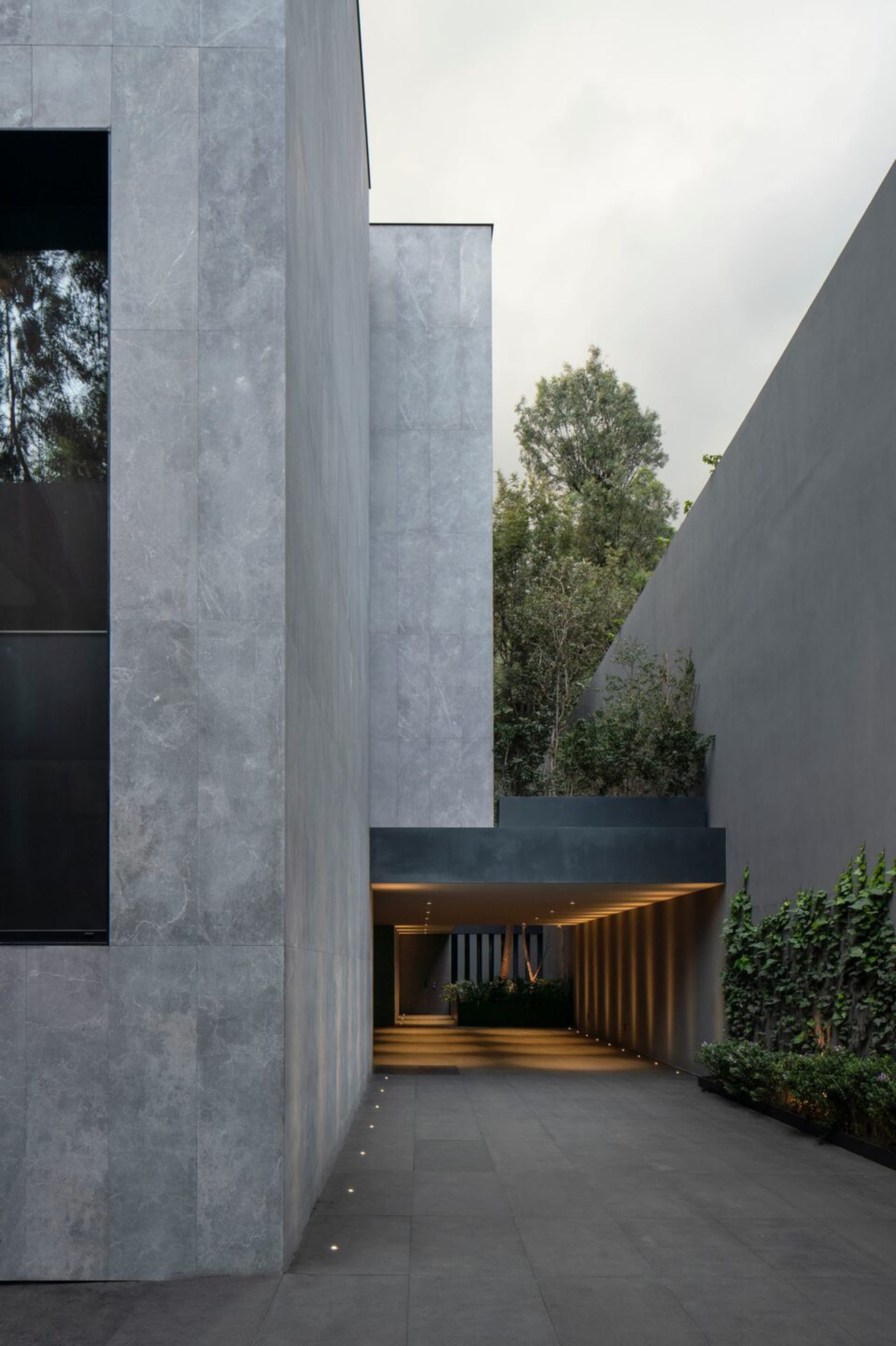 Modern building with concrete exterior and greenery.