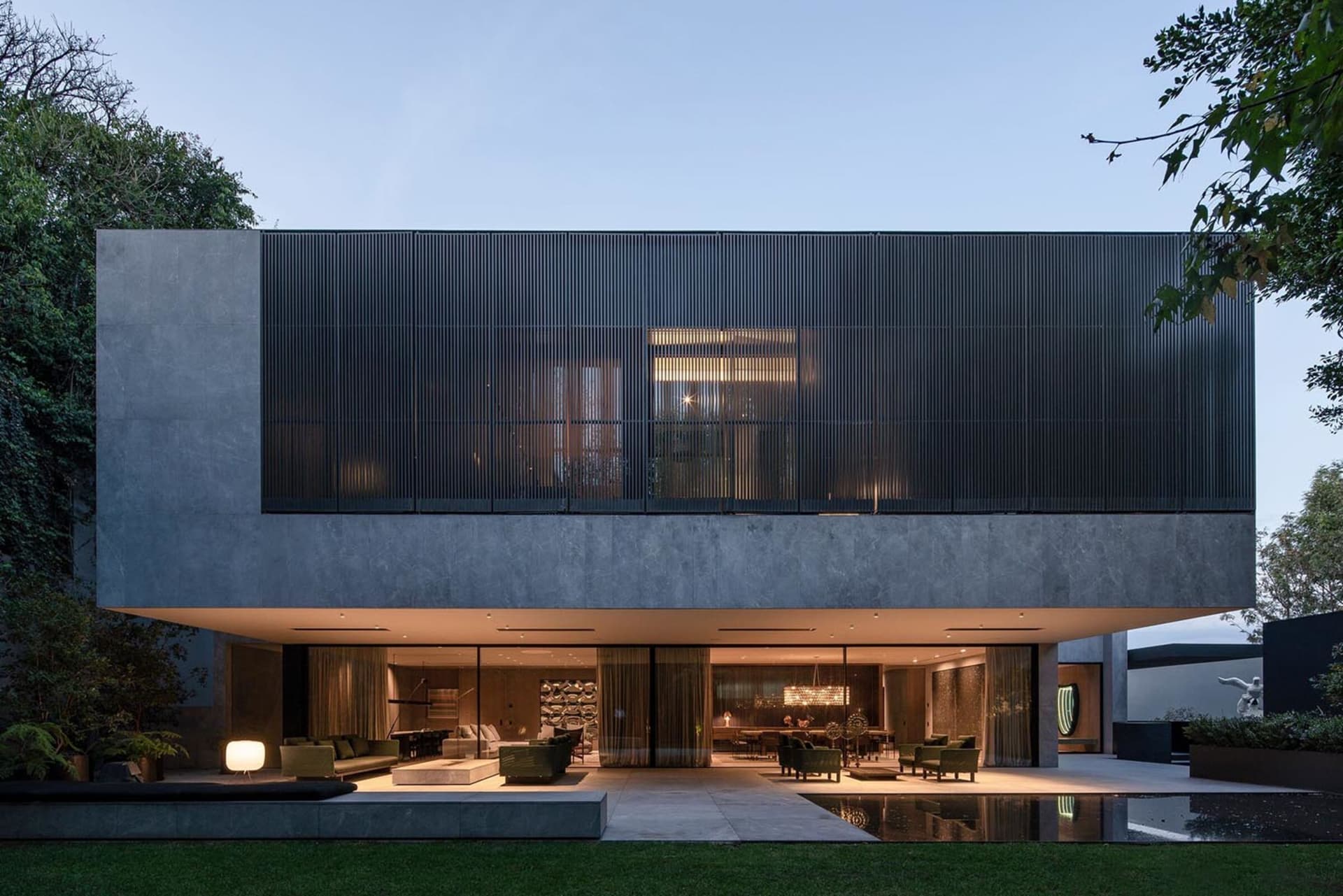 Modern minimalist living room with concrete and glass elements.
