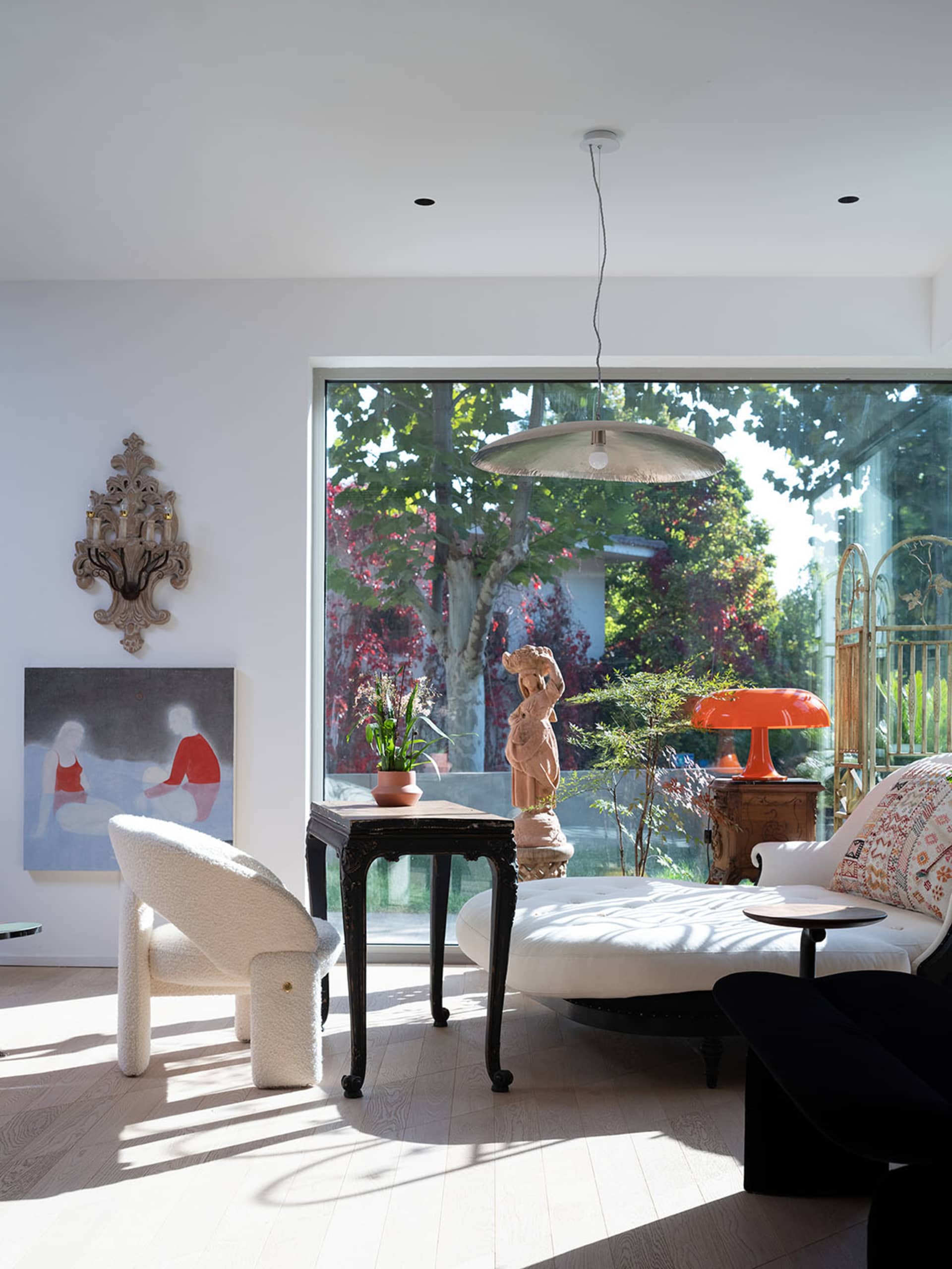 Modern living room with white furniture, a large window, and a wooden floor.