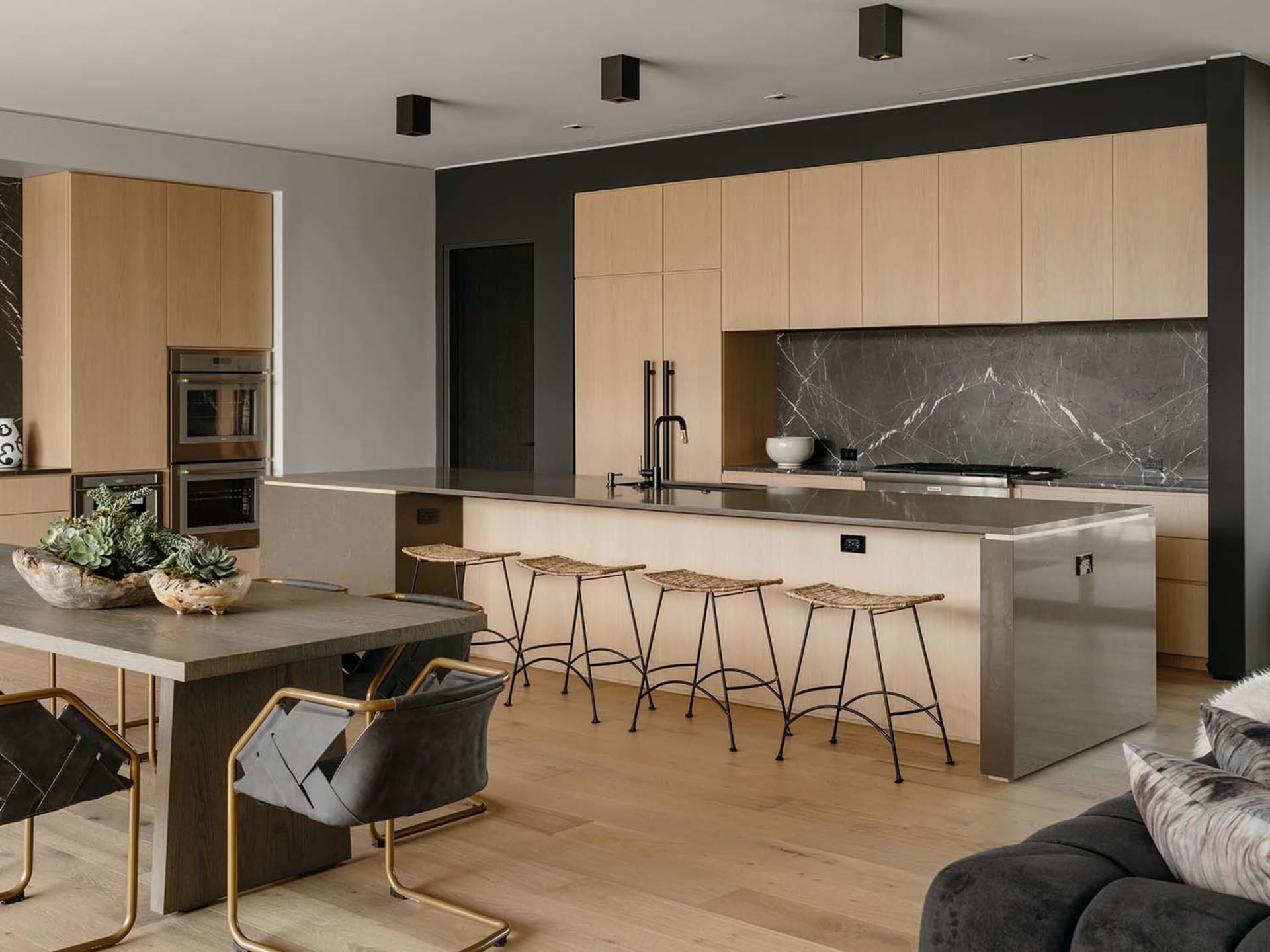 Modern residential kitchen featuring wooden cabinets and a marble backsplash.