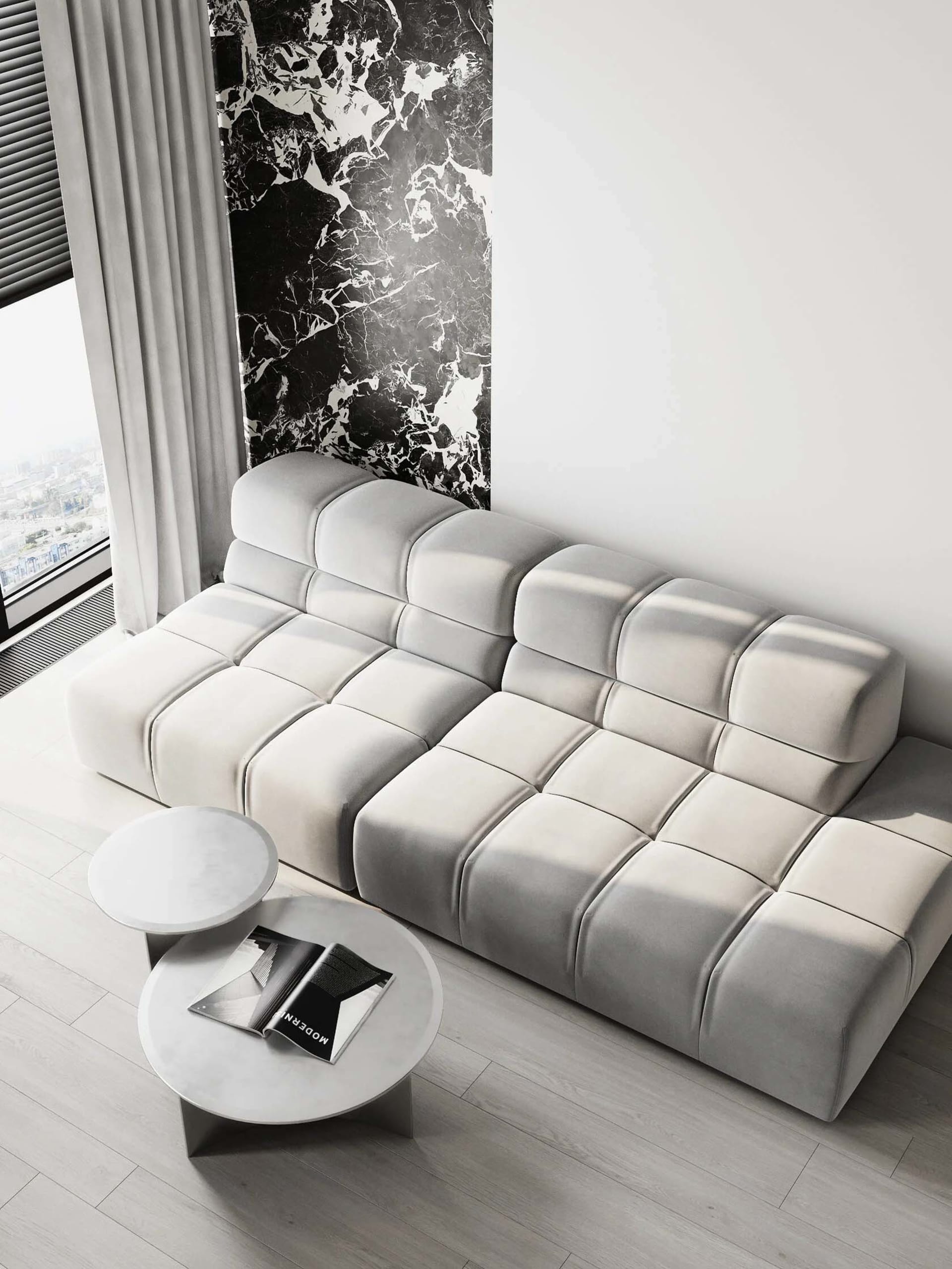 White modular sofa with tufted cushions in a modern living room featuring marble accents.
