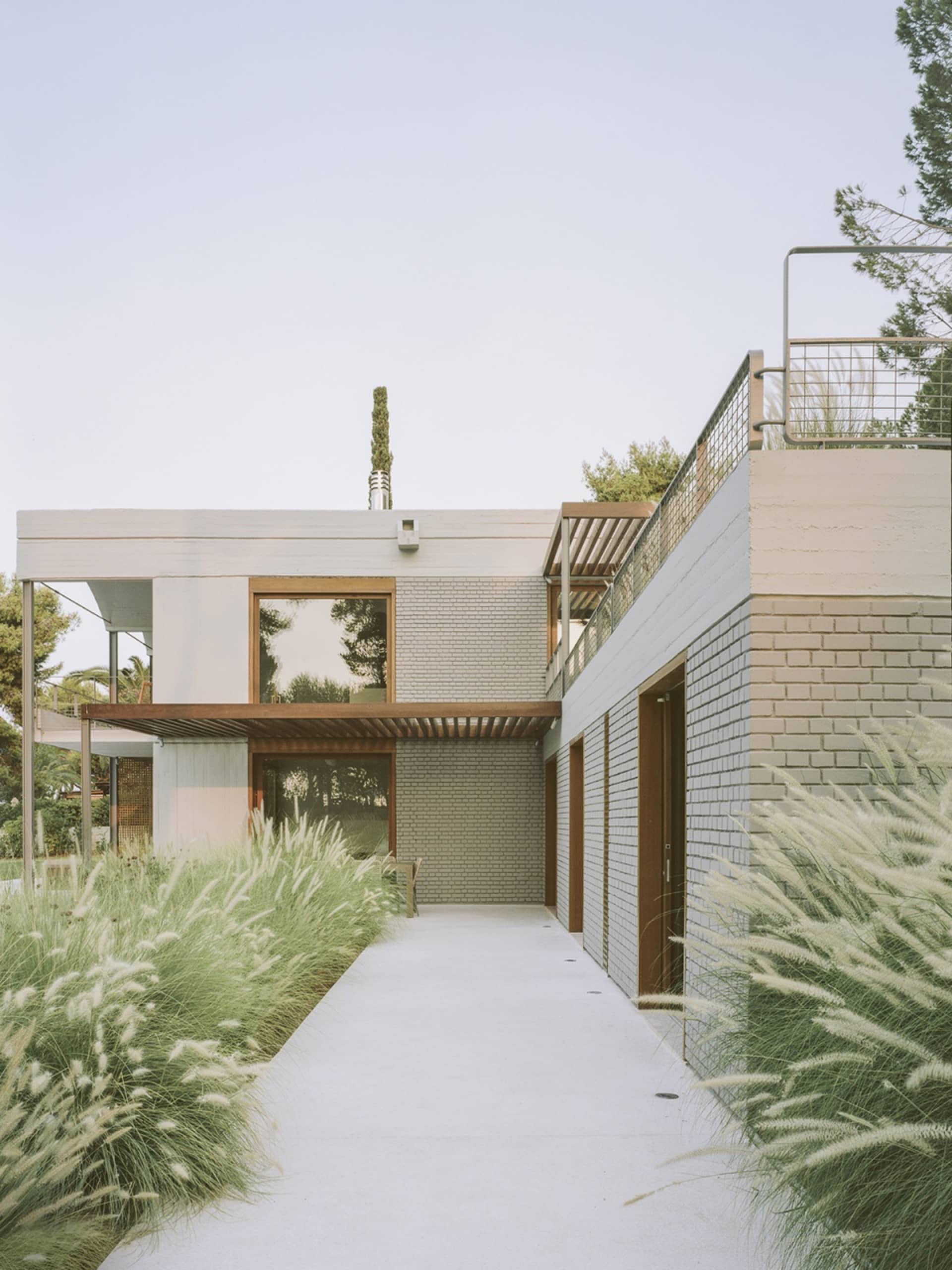 Modern house exterior with brick, concrete, and steel materials.