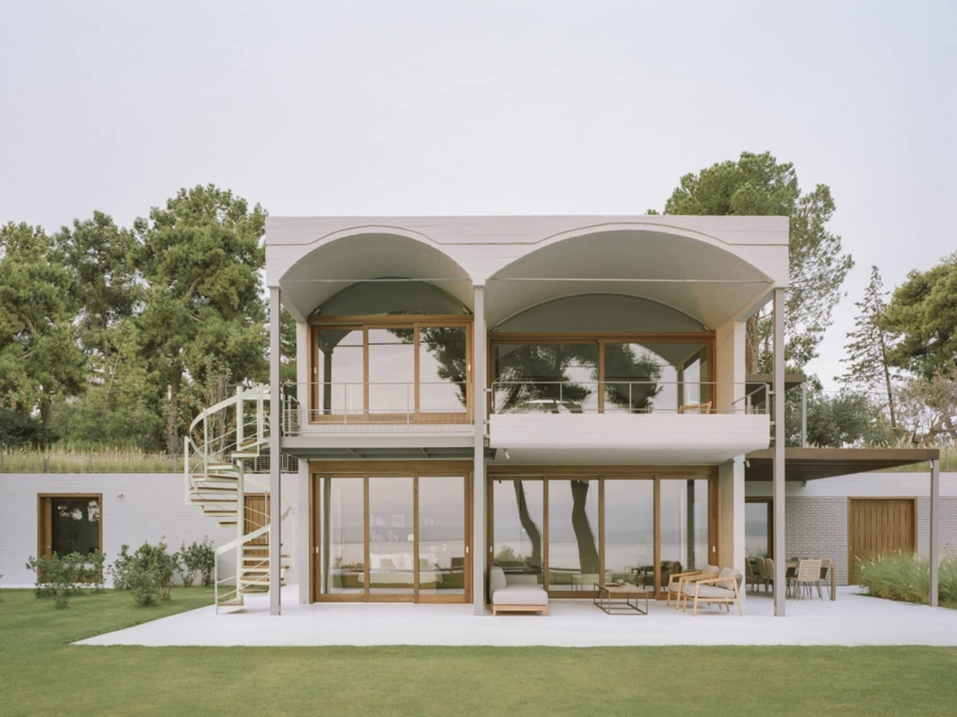 A modern house with concrete, glass, and metal exterior features.