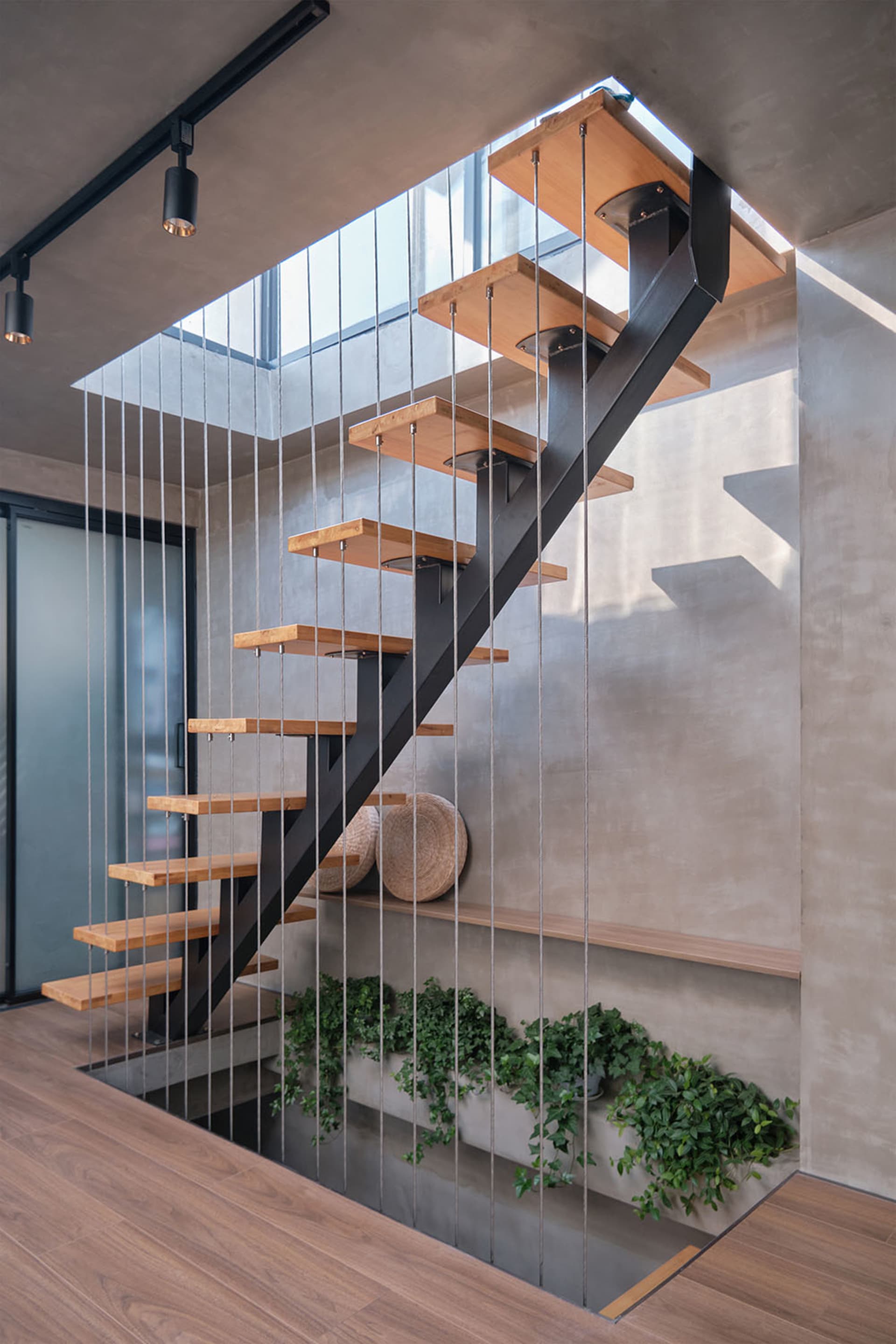 Modern interior staircase with metal balustrade and wooden treads and risers.
