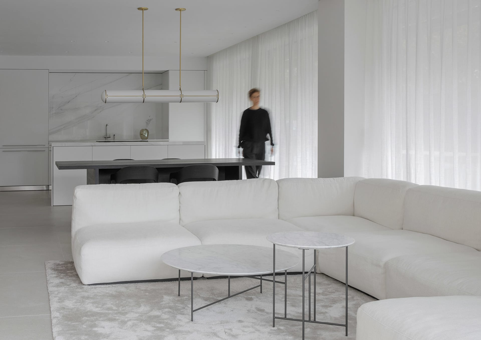 Living room with modern interior design featuring marble and white cotton blend furniture and accessories.