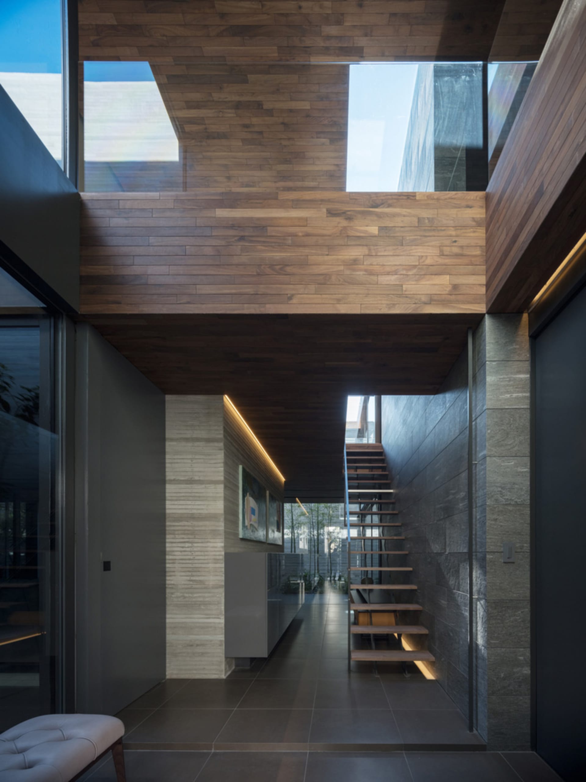 A modern, minimalist staircase with wooden flooring and a contemporary design, featuring a sleek and clean aesthetic.