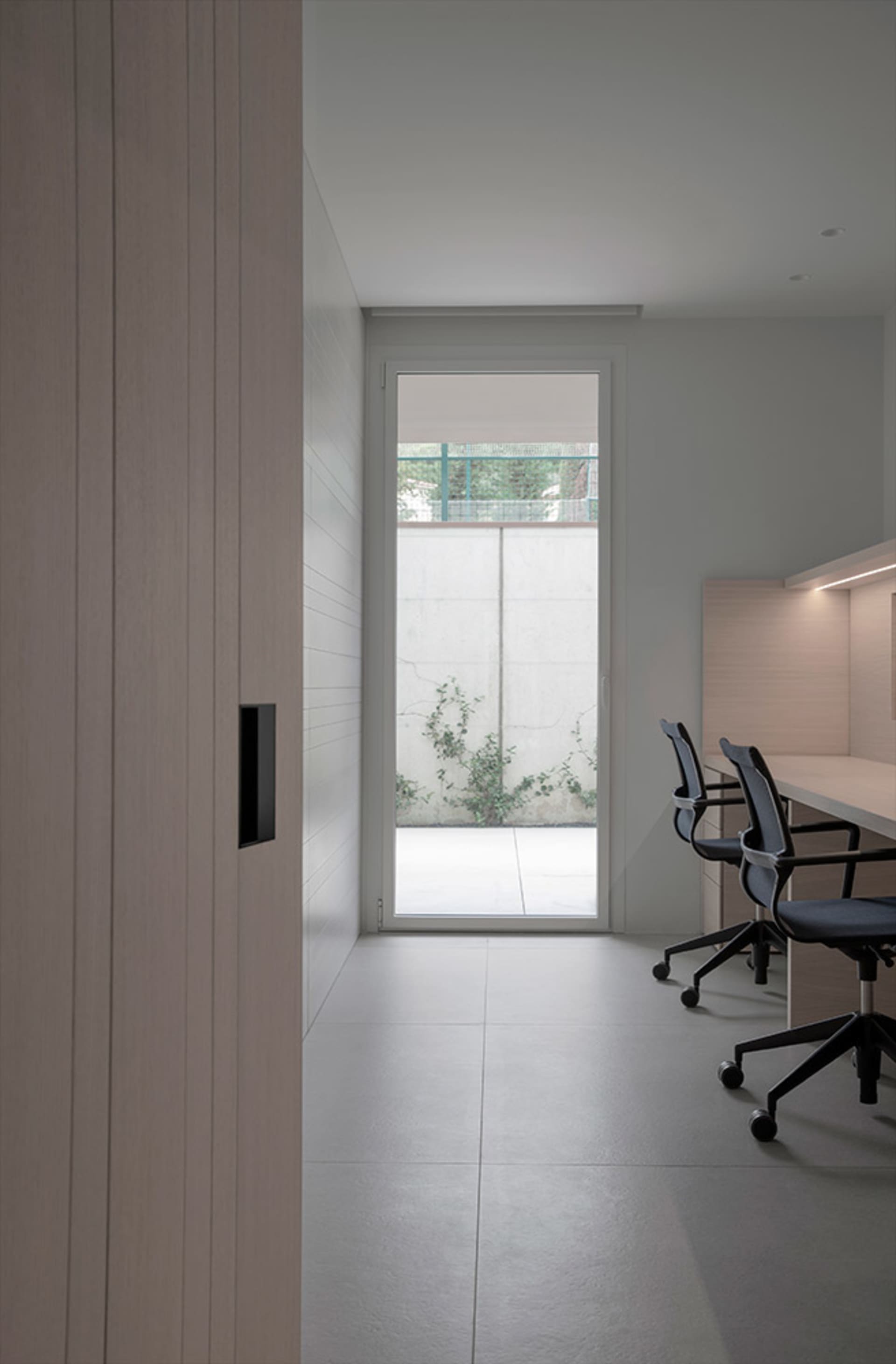 Modern office with concrete floor and large window.