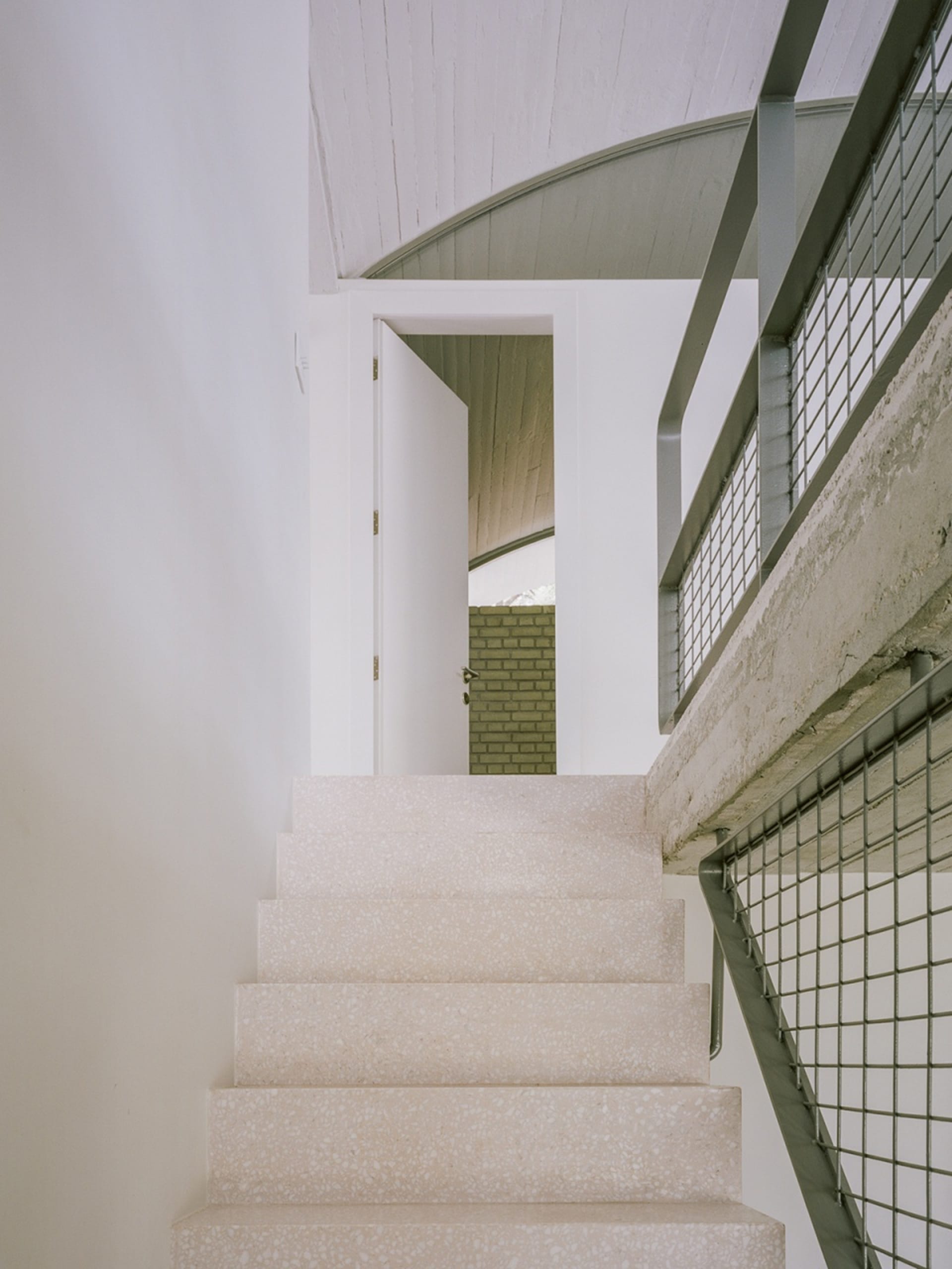A modern staircase with concrete steps and a metal railing.