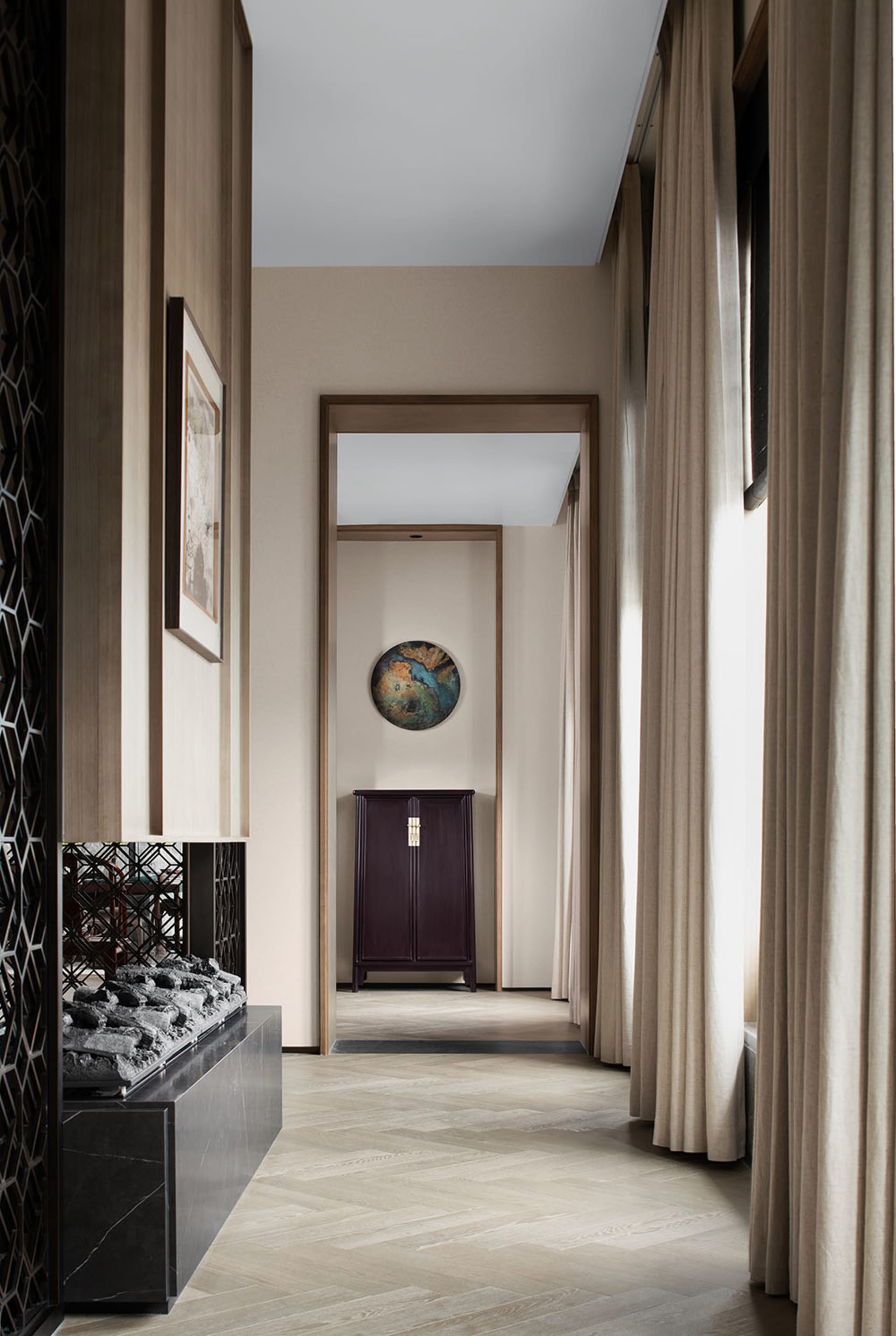 Modern hallway with a wooden floor, warm-toned walls, and fabric curtains.
