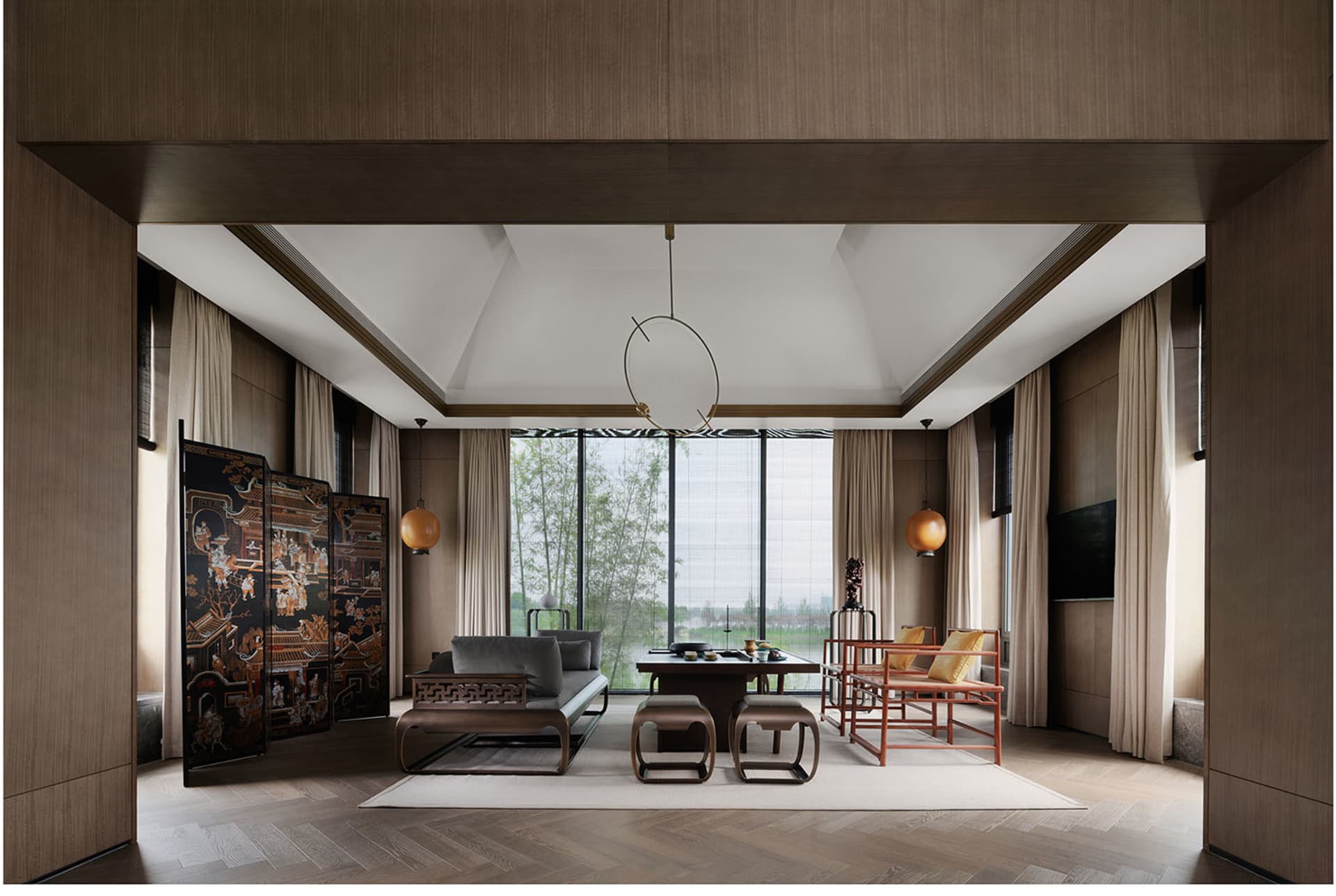 Modern living room featuring wooden furniture and white curtains with a large window overlooking greenery.
